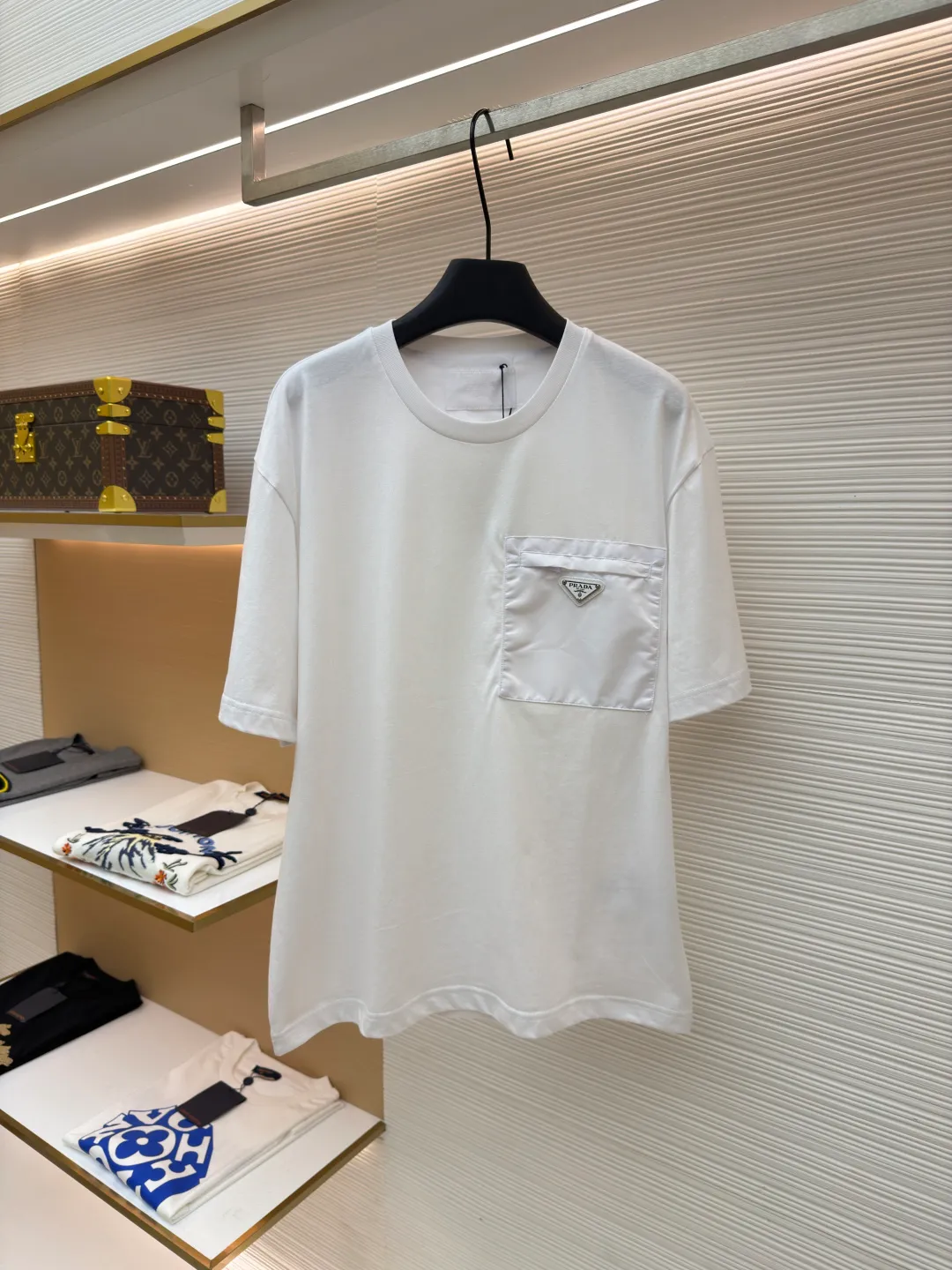 Prada Triangle Logo Pocket Short Sleeves ●Original version: Purchased and developed for 7000 ●Item number: 1682395-A05 ●Fabric: High-elastic jersey fabric ●Technology: Needle and shuttle splicing ●Color: white ●Version: Fitted version ●Weight: about 230 grams ●Size: S-M-L-XL ●Description: Customized high-elastic jersey material, delicate and soft, comfortable and close to the skin, a touch of simple white, as pure as ever, elegant and self-evident The iconic Prada triangle logo is embellished on the chest. It is integrated with Re-Nylon nylon fabric to decorate the square silhouette. Cross-disciplinary aesthetic grafting. The exquisite small pocket design highlights quality and style. It reveals a flexible and relaxed beauty. It is a picture of strolling in the city and deconstructs the attitude of the modern gentleman. The infrared positioning of the "Prada triangle mark" by an imported special machine is more precise and firm. Needle and shuttle stitching technology can make full use of the respective advantages of knitted fabrics and woven fabrics. By choosing the appropriate sewing process and stitches, it can ensure that the splicing parts are strong and beautiful. Template machine bag opening The preset template guides the position, shape and size of the bag opening. The accuracy ensures the quality of the bag opening effect. The overall wiring is straight and delicate, the fabric is comfortable and soft, and the color is consistent without color difference. It can be matched with the same style to create a fashionable look and control various occasions. Customized accessories, complete with three standards, same style for men and women!