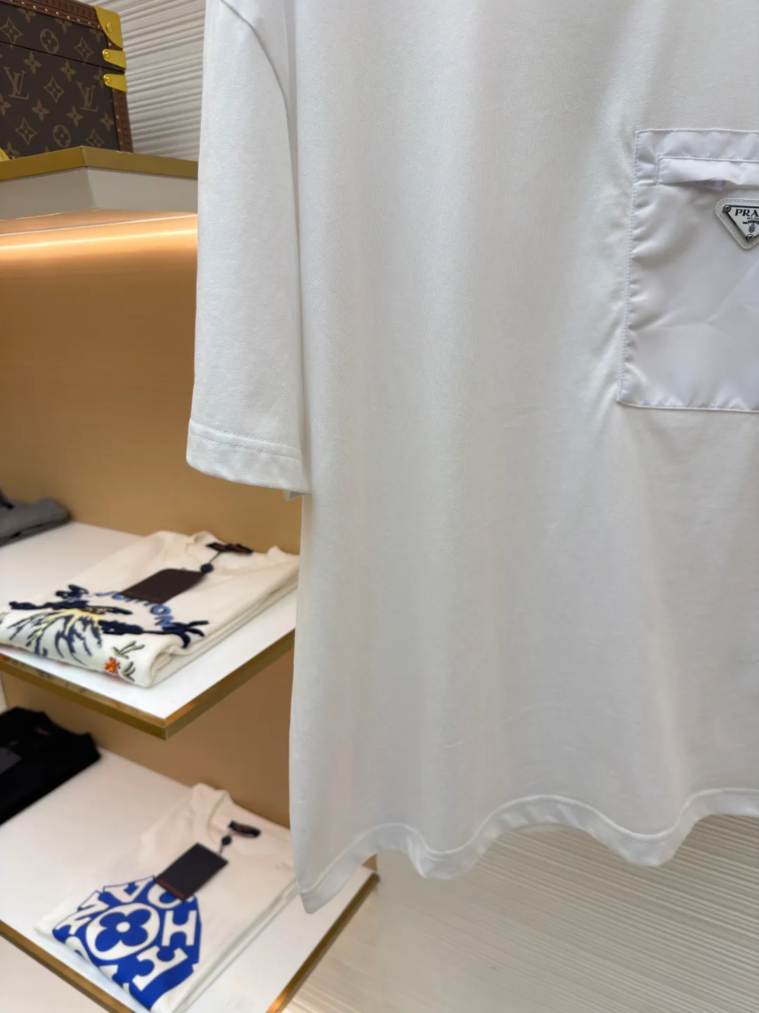 Prada Triangle Logo Pocket Short Sleeves ●Original version: Purchased and developed for 7000 ●Item number: 1682395-A05 ●Fabric: High-elastic jersey fabric ●Technology: Needle and shuttle splicing ●Color: white ●Version: Fitted version ●Weight: about 230 grams ●Size: S-M-L-XL ●Description: Customized high-elastic jersey material, delicate and soft, comfortable and close to the skin, a touch of simple white, as pure as ever, elegant and self-evident The iconic Prada triangle logo is embellished on the chest. It is integrated with Re-Nylon nylon fabric to decorate the square silhouette. Cross-disciplinary aesthetic grafting. The exquisite small pocket design highlights quality and style. It reveals a flexible and relaxed beauty. It is a picture of strolling in the city and deconstructs the attitude of the modern gentleman. The infrared positioning of the "Prada triangle mark" by an imported special machine is more precise and firm. Needle and shuttle stitching technology can make full use of the respective advantages of knitted fabrics and woven fabrics. By choosing the appropriate sewing process and stitches, it can ensure that the splicing parts are strong and beautiful. Template machine bag opening The preset template guides the position, shape and size of the bag opening. The accuracy ensures the quality of the bag opening effect. The overall wiring is straight and delicate, the fabric is comfortable and soft, and the color is consistent without color difference. It can be matched with the same style to create a fashionable look and control various occasions. Customized accessories, complete with three standards, same style for men and women!