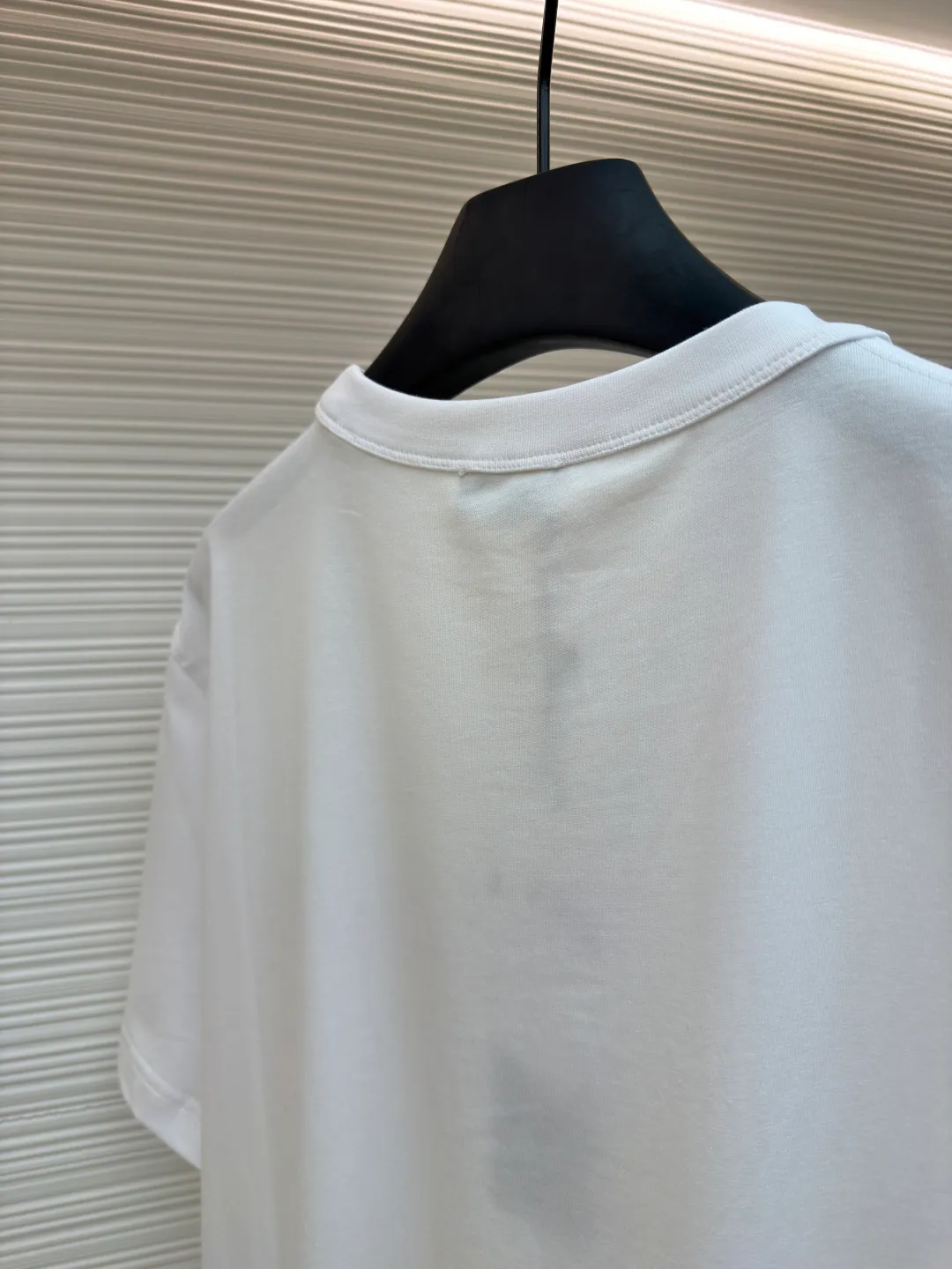 Dior satin emblem round neck short sleeves ●Original version: purchased and developed by 7089 ●Item number: 1681695-A00 ●Fabric: cotton jersey fabric ●Technology: embroidery production ●Color: white ●Version: fitted version ●Weight: about 205 grams ●Size: XS-S-M-L ●Description: The main body is made of 24-count special-spun compact cotton. The weight of 185g/㎡ is light to medium, ensuring the lightness, breathability and good drape of the T-shirt. It is suitable for both spring wear alone and as an inner layer. With 32 pieces of 1×1 rib, 300g/㎡. Its special spinning and compacting process means that compact spinning technology is used in the spinning process, which effectively reduces the hairiness of the yarn, making the yarn smoother and stronger. The woven fabric therefore has the advantages of compact structure, smooth surface, and resistance to pilling. The final dark gray tone is combined with the simple texture of jersey to create a high-end matte texture. Embroidery decoration in the form of satin ribbons, which are fixed on the fabric through special processing. The texture brought by this process is usually different from the woven texture and slight luster of the main knitted fabric. It forms a delicate and accessible visual and tactile focus on the matte dark gray base, enhancing the craftsmanship, design and uniqueness of the single product. The overall wiring is straight and delicate, the fabric is comfortable and soft, and the color is consistent without color difference. It can be matched with the same style to create a fashionable look and control various occasions. Customized accessories, complete with three standards, same style for men and women!