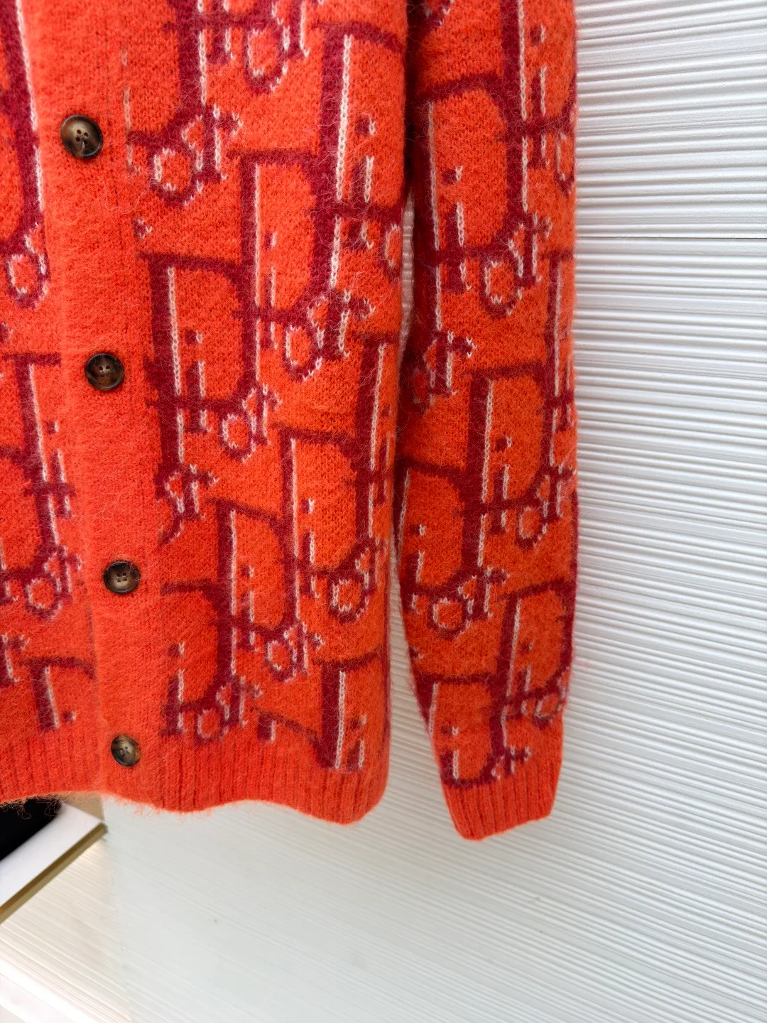 Dior mohair knitted cardigan ●Original version: 21000 purchased and developed ●Item number: 1681335-B60 ●Fabric: mohair fabric ●Technology: knitted ●Color: orange ●Version: fitted version ●Weight: about 725 grams ●Size: S-M-L-XL ●Description: This cardigan is made of mohair blended fabric, which is soft to the touch and has a fluffy texture. The brand's classic letter jacquard is displayed all over the body, which is realized through two-color knitting technology. The pattern texture is clear and three-dimensional, and the colors are distinct. The round neck design is processed by ribbing edge processing, and the neckline is stiff and not easy to deform; the placket is equipped with retro metal buttons, the color is old and echoes the overall style. The ribs on the cuffs and hem are made of high-elastic knitting technology to ensure good fit and resilience. The overall cut is a loose fit, and the splicing of the body uses seamless weaving technology to avoid exposed threads and improve wearing comfort. From jacquard craftsmanship to detail processing, every step reflects the exquisite control of luxury knitwear. It is a fusion of the brand's classic elements and high-end knitting craftsmanship. The overall wiring is straight and delicate, the fabric is comfortable and soft, and the color is consistent without color difference. It can be matched with the same style to create a fashionable look and control various occasions. Customized accessories, complete with three standards, same style for men and women!