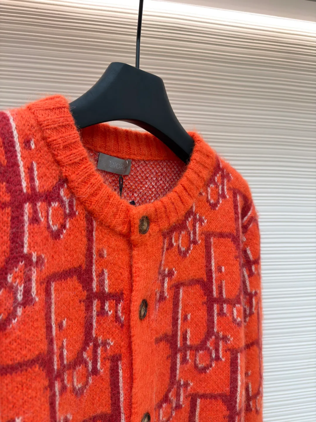 Dior mohair knitted cardigan ●Original version: 21000 purchased and developed ●Item number: 1681335-B60 ●Fabric: mohair fabric ●Technology: knitted ●Color: orange ●Version: fitted version ●Weight: about 725 grams ●Size: S-M-L-XL ●Description: This cardigan is made of mohair blended fabric, which is soft to the touch and has a fluffy texture. The brand's classic letter jacquard is displayed all over the body, which is realized through two-color knitting technology. The pattern texture is clear and three-dimensional, and the colors are distinct. The round neck design is processed by ribbing edge processing, and the neckline is stiff and not easy to deform; the placket is equipped with retro metal buttons, the color is old and echoes the overall style. The ribs on the cuffs and hem are made of high-elastic knitting technology to ensure good fit and resilience. The overall cut is a loose fit, and the splicing of the body uses seamless weaving technology to avoid exposed threads and improve wearing comfort. From jacquard craftsmanship to detail processing, every step reflects the exquisite control of luxury knitwear. It is a fusion of the brand's classic elements and high-end knitting craftsmanship. The overall wiring is straight and delicate, the fabric is comfortable and soft, and the color is consistent without color difference. It can be matched with the same style to create a fashionable look and control various occasions. Customized accessories, complete with three standards, same style for men and women!