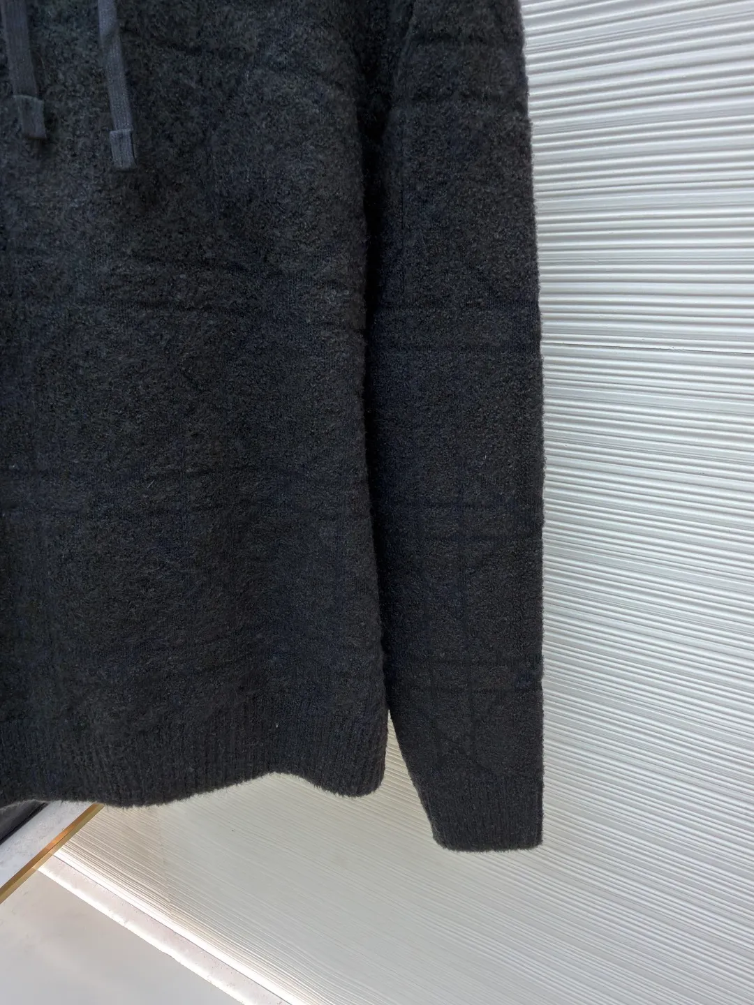 Dior diamond pattern jacquard knitted hoodie ●Original version: 24000 purchased and developed ●Item number: 1681969-C70 ●Fabric: wool blended fabric ●Technology: jacquard knitting ●Color: black ●Version: fitted version ●Weight: about 1415 grams ●Size: S-M-L-XL ●Description: This is LV The 2025 autumn and winter series of plush hooded sweaters are made of 100% Albaka wool blend, and the yarn contains 30% alpaca. It is woven with a 16-needle coarse weaving process. The surface presents a matte plush texture and is twice as warm as ordinary wool. The main body of the garment is made of rhombus plaid jacquard, with a three-dimensional texture formed by alternating front and back stitching techniques without additional seams. The hood is made of one-piece knitting, with an invisible shaping lining built into the brim, making it more comfortable to wear. The drawstring is made of core-spun rope of the same material, and the rope ends are treated with metal crimping, making it durable and not easy to wear. The finished product is ironed with low-temperature steam to avoid damage to the plush fibers. The cuffs and hem are ribbed for long-lasting elasticity and a good fit. The whole piece is sewn in an Italian workshop, with no exposed threads in the details, continuing the exquisite standards of the brand's high-end knitted items. The overall stitching is straight and delicate, the fabric is comfortable and soft, and the color is consistent with no color difference. It can be matched with the same style to create a fashionable look and control various occasions. Customized accessories, complete with three standards, the same style for men and women!