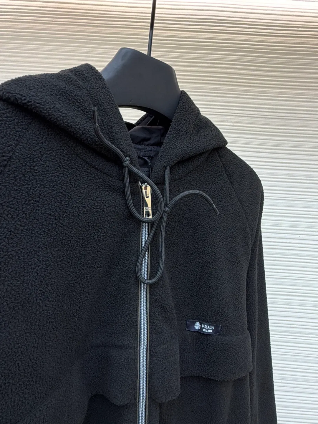 Prada Polar Fleece Jacket ●Original version: Purchased and developed by 13138 ●Item No.: 1682329-B50 ●Fabric: Polar fleece fabric ●Technology: Positioned cutting machine production ●Color: black ●Version: Fitted version ●Weight: about 635 grams ●Size: S-M-L-XL ●Description: The woven fabric is brushed, that is, the fiber surface is fluffed through mechanical brushing to form fluff. Then the shaking process is carried out. The fabric is shaken under high temperature and humid conditions, so that the fibers form small spherical particles, which increases the fluffiness and warmth of the fabric. Polar fleece fabric undergoes a dyeing process to ensure uniform and long-lasting color. After dyeing, the fabric undergoes finishing processes such as shaping and calendering to improve the feel and appearance. Splice the cut parts (such as front and back panels, sleeves, hats, etc.) according to the design requirements. When splicing, you need to pay attention to aligning the seams to ensure that the splicing is smooth and wrinkle-free. For parts that are prone to wear, such as collars, cuffs, and hems, hemming is used to increase elasticity and durability. At the same time, details such as zippers and pockets also need to be carefully processed to ensure functionality and aesthetics. Choose high-quality metal zippers to ensure that the zippers are smooth and durable. The color of the zipper needs to be coordinated with the color of the main body of the jacket to enhance the overall aesthetics. The overall wiring is straight. Delicate, the fabric is comfortable and soft, the color is consistent and there is no color difference. It can be matched with the same style to create a fashionable look and control various occasions. Customized accessories, complete with three standards, same style for men and women!