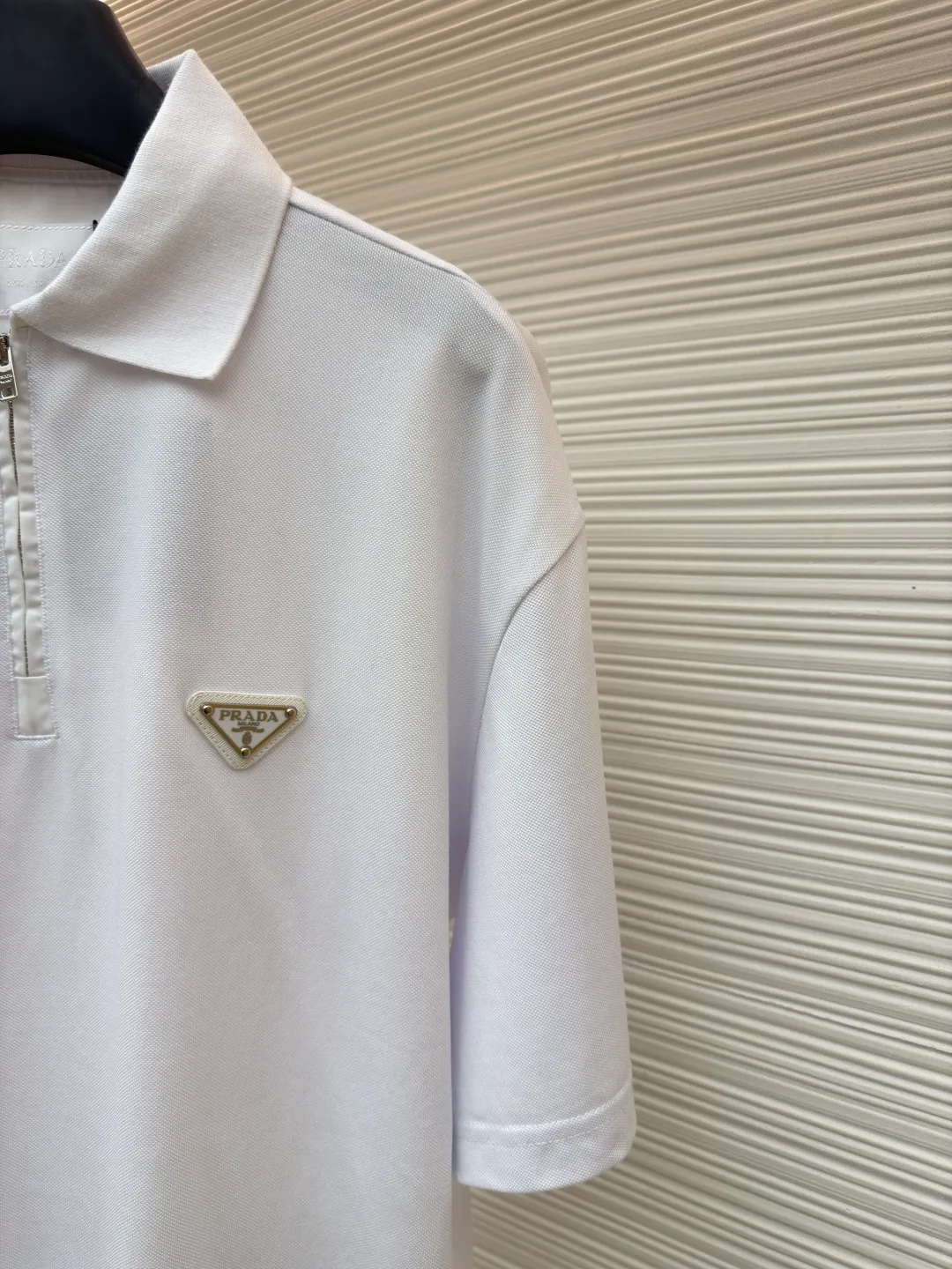 Prada triangle logo Polo shirt ●Original version: Purchased and developed for 7600 ●Item number: 1682423-A10 ●Fabric: pique cotton fabric ●Technology: Fabric washing and production ●Color: white ●Version: Fitted version ●Weight: about 310 grams ●Size: S-M-L-XL ●Description: Customized Jing embroidered Qiluo cotton pique silk, delicate and smooth, tight and elastic texture The iconic enamel-coated triangular metal logo is embellished to highlight the elegance and nobility of the brand. It is integrated with zipper fashion elements. Casual yet stylish, elegant yet fashionable, a fashionable and versatile item. It shines with a unique light. The "Prada triangle mark" is positioned more accurately using imported special infrared machines. It is strong and strong, and the fabrics have been washed. It has a better hand feel and texture. It is not easy to deform, not easy to shrink, not easy to fade, and maintains long-term beauty. The overall wiring is straight and delicate, the fabric is comfortable and soft, and the color is consistent without color difference. It can be matched with the same style to create a fashionable look and control various occasions. Customized accessories, complete with three standards, same style for men and women!