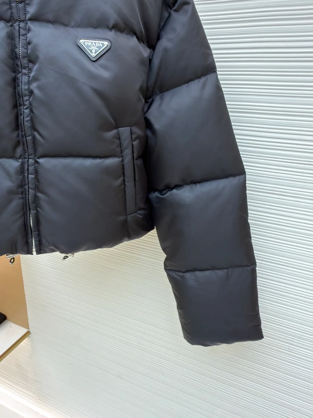 Prada High Waist Stand Collar Down Jacket [Women's Clothing] ●Original version: Purchased and developed by 15021 ●Item number: 1681052-D50 ●Fabric: cashmere fabric ●Technology: Precision double-needle quilting ●Version: fitted version ●Weight: about 710 grams ●Size: 36-38-40 ●Description: The brand's iconic regenerated nylon fabric is selected, which has the same performance as traditional nylon and has high strength, tear resistance, wear resistance and other characteristics. It is lightweight and waterproof, suitable for various scenarios. Anti-wrinkle, quick-drying and easy to maintain on a daily basis. The lining is made of 100% polyamide. Polyamide fiber is known for its extremely high strength and excellent skin-friendly feel. It feels silky smooth and avoids the friction and discomfort that may occur when wearing heavy underwear. It works together with the outer layer of nylon to create a breathable, temperature-locking, and extremely comfortable microclimate environment, allowing warmth and care to be online at all times without feeling stuffy or restrictive. It uses 90 white duck down with a weight of 280g to ensure excellent thermal insulation performance. After strict screening and treatment, the down is not easy to drill down, ensuring durability and warmth. The core is to use advanced down filling technology to evenly fill each independent vertical lining square with precious 90% high-quality white duck down. This process effectively prevents the accumulation or sinking of velvet during wearing, ensuring all-round warmth from the front, back, left, and right without any dead ends. At the same time, the silhouette of the garment is always full and crisp, avoiding bloat. All stitches adopt the precision double-needle quilting process that is highly recommended in the industry. The stitches are fine and even, like rigorous defense lines. It is not only strong and beautiful, but also greatly eliminates the trouble of velvet coming out of the stitches, ensuring the product's long-lasting warmth retention performance. The overall wiring is straight and delicate, the fabric is comfortable and soft, and the color is consistent without color difference. It can be matched with the same style to create a fashionable look and control various occasions. Customized accessories, complete with three standards, same style for men and women!