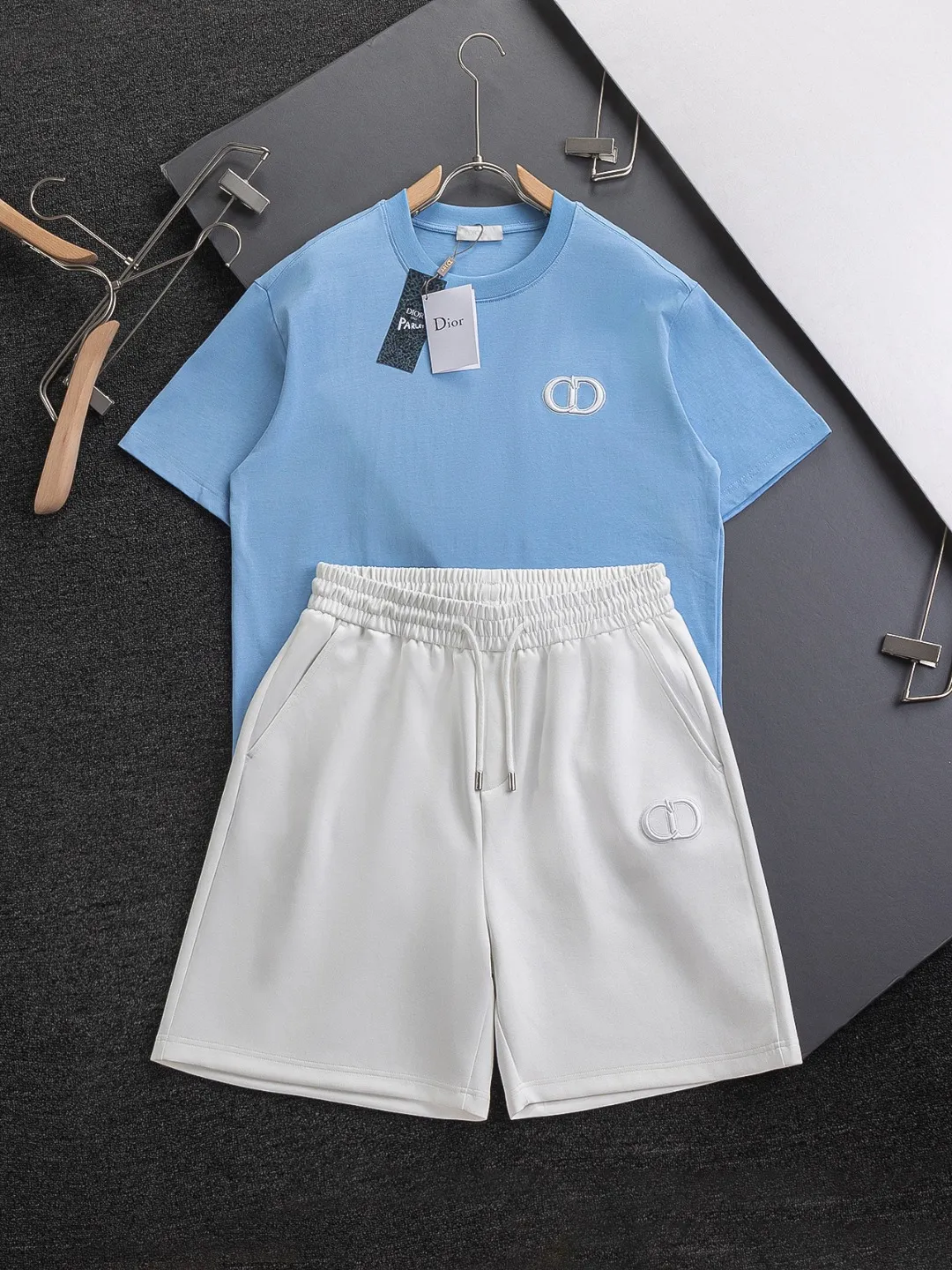 🅿️370 Dior CD micro-wide version S-XL (suit) CD 25SS New product official website for sale at the same time Simple CD letter short-sleeved shorts on the front 🪡 Embroidered logo pattern Back pocket As the leader in the luxury world, the D family is well-deserved. The first thing that catches the eye is the loose and comfortable three-color solid color black, white and blue. The ribbed short-sleeved shorts have become the best modification of the style, and the D family has the upper and lower body LOGOs listed on the chest. It also has a unique letter logo patch embroidery design, which highlights the texture! The most traditional modification method combined with the simplest color scale contrast forms the strongest and direct contrast, and this is often the most concise and clear minimalist modification method~~A nostalgic classic atmosphere also spreads in this work inadvertently! ! Featuring a distinctive 47 logo patch embroidery on the front, a unique tribute to Dior's historic year! Coupled with the blessing of cotton material, both the upper body comfort and the existence are unparalleled. It can be said to be a must-have companion in summer. The excellent breathability and comfortable wearing feeling are unparalleled~ Recommended! ! Color: Black White White + Blue Black + Blue Size Chart: S: Shoulder Width 45.5-Bust 52-Length 70 M: Shoulder Width 47-Bust 54-Length 72 L: Shoulder Width 48.5-Bust 56-Length 74 XL: Shoulder Width 50-Bust 58-Length 76 Pants Size: S-XL Size Chart: S: Sitting circumference 58 - Waist circumference 54 - Trouser length 43.5 M: Sitting circumference 60 - Waist circumference 56.5 - Trouser length 45 L: Sitting circumference 62 - Waist circumference 59 - Trouser length 46.5 XL: Sitting circumference 64 - Waist circumference 61.5 - Trouser length 48