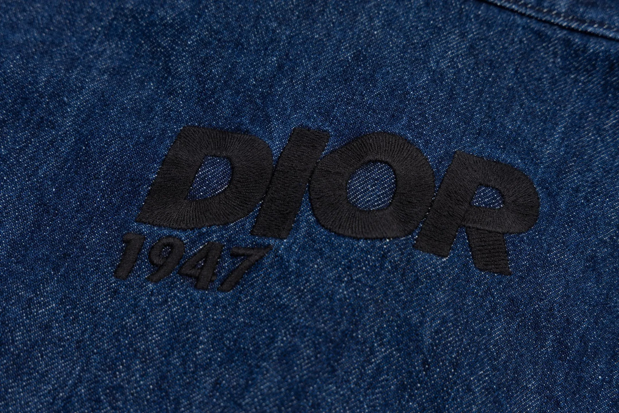 🅿️600 CD 26SS 1947 letter embroidered denim jacket. This jacket shirt is a new product of the 2026 spring men's wear series. It is decorated with multi-color patches, showing the alpine spirit and the classic logo of high-end style inspired by CD archives. Crafted from blue cotton denim for a lightweight feel, it features embroidery on the chest pocket and back. It features a front zipper closure and can be paired with the matching jeans for a sophisticated look. Using high-count cotton denim, through weight reduction textile technology and special washing treatment, while retaining the twill texture and denim durability, the fabric weight has been successfully reduced to the ideal state. The finished product has a cloud-like soft and waxy feel and excellent drape, which subverts the heavy impression of denim. The three-dimensional layering is created through patch pocket technology with a strong hand-feel, and delicate letter outlines are constructed on the chest and back using contrasting embroidery threads and three-dimensional embroidery techniques. The stitch density has been carefully calculated to ensure that the pattern still maintains a high-definition level of clarity despite the rough texture of the denim. The overall structure adopts a jacket-like shirt structure, with precision toothed chain and pull tab design as the opening and closing design, taking into account smooth operation experience and windproof performance. Functional details such as chest patch pockets inside and outside continue the pragmatic logic, and all seam interfaces are secondary reinforced to meet the durability needs of outdoor scenes while maintaining the contours. Size:44-46-48-50