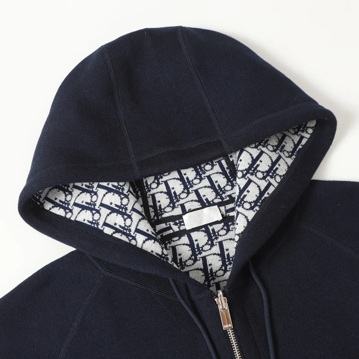 🅿️650 [Original quality] CD/Dior 24FW jacquard double-sided cashmere jacket (navy blue) The fabric is made of cotton and cashmere blended fabrics, and is made of high-quality wool and cashmere, which is soft and comfortable to the touch. The navy blue cotton blended knitted fabric is carefully crafted using imported machine jacquard technology. One side is decorated with the classic presbyopia logo jacquard pattern, and the other side is a simple white design. It can be worn on both sides. The drawstring hood is paired with metal hardware engraved with the Dior logo, adding refined detail. It features practical patch pockets on the front, and a ribbed hem and cuffs ensure a form-fitting fit. The double zipper with monogram highlights the brand's signature, and the raglan sleeves are cut in a smooth, natural style. The front is embellished with the Dior embroidered logo, and the inside is decorated with Oblique print throughout, with exquisite details. Pair with the matching sports trousers for an elegant and casual look. The whole piece integrates high-end craftsmanship into daily items, showing the brand's exquisite craftsmanship and classic aesthetics. Size:S/M/L/XL