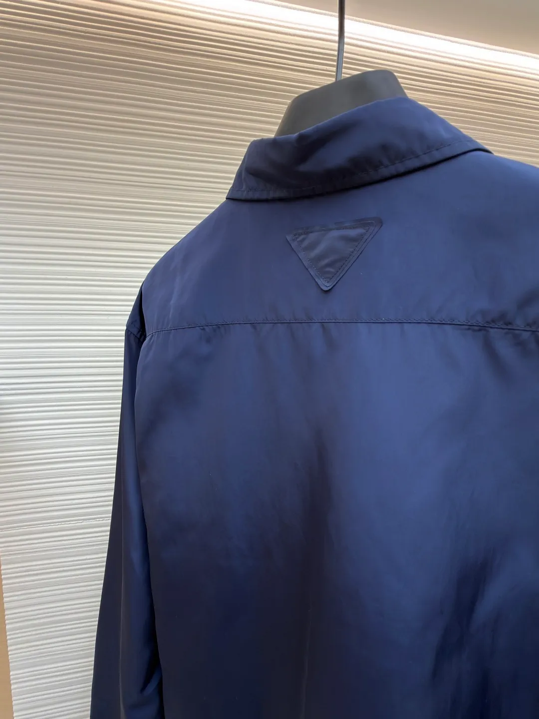 Prada triangle emblem label shirt ●Original version: Purchased and developed by 8100 ●Item number: 1682219-A75 ●Material: Regenerated nylon fabric ●Technology: Human body draping and production ●Color: blue ●Version: Fitted version ●Weight: about 180 grams ●Size: 39-40-41-42 ●Description: Custom-dyed regenerated nylon material feels like futuristic technology, light and tough, comfortable and skin-friendly Reconstructing the aesthetics of masculine power with deep sea blue tones. It has a mysterious and elegant aura. The Prada logo label is embellished on the chest patch pocket and complements the triangular logo on the back fabric to express the brand identity. The slightly wide shoulder line and curved hem form an architectural-level silhouette. The visual aristocratic gene, minimalism and luxury coexist, interpreting high-end fashion style. Silk double yarn interweaving processing technology uses nano-imprint technology to build honeycomb-shaped protrusions on the surface of the fabric, and then uses high temperature and high pressure to form covalent bonds between fluorine atoms and nylon fibers, forming a micro-matte film layer on the surface to prevent oil stains from reducing the waterproof performance. Three-dimensional tailoring of the human body returns to traditional craftsmanship through segmentation, folding, shrinking, and stretching techniques. The so-called slow work produces fine work, which is the respect for the material and the pursuit of feel. The workmanship is complicated and tedious, and the timeliness is slow. The side-turning buried clamping line process is used to make it smooth, neat, and tidy. The overall wiring is straight and delicate, the fabric is comfortable and soft, and the color is consistent without color difference. It can be matched with the same style to create a fashionable look and control various occasions. Customized accessories, complete with three standards, same style for men and women!
