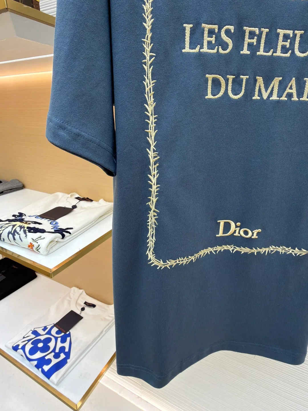 Dior thorn embroidery round neck short sleeves ●Original version: purchased and developed by 13939 ●Item number: 1682473-A05 ●Fabric: cotton jersey fabric ●Technology: embroidery production ●Color: blue ●Version: fitted version ●Weight: about 275 grams ●Size: XS-S-M-L ●Description: Made of blue 12-count cotton jersey fabric with a weight of 230g/㎡; the neckline is made of 32-count double-yarn high-weight (350g) ribbing, which uses extremely high density and elasticity to provide solid neckline support for the loose body and prevent deformation. The fabric is medium thick and provides good stiffness and durability. The 12-count yarn is relatively thick, giving the fabric a rustic texture and casual attributes. Fabrics interwoven with plain weave have many buckling points in the yarns, giving the fabric good fastness and wear resistance. The density is moderate, the fabric is thin, flat and stiff. It has good breathability, is softer, more delicate, and has better gloss. Multi-color computer embroidery technology is used to restore the complex details, text, patterns, etc. of the book cover. Based on the high-precision artwork on the cover of the first edition of "Flowers of Evil", white embroidery thread is used to perform high-density embroidery through a combination of flat stitch, satin embroidery, chain embroidery and other stitching methods. With exquisite and textured handicrafts, the artistic details of literary classic covers are vividly reproduced, and the flat image is transformed into a three-dimensional touch and rich layers. The overall wiring is straight and delicate, the fabric is comfortable and soft, and the color is consistent without color difference. It can be matched with the same style to create a fashionable look and control various occasions. Customized accessories, complete with three standards, same style for men and women!