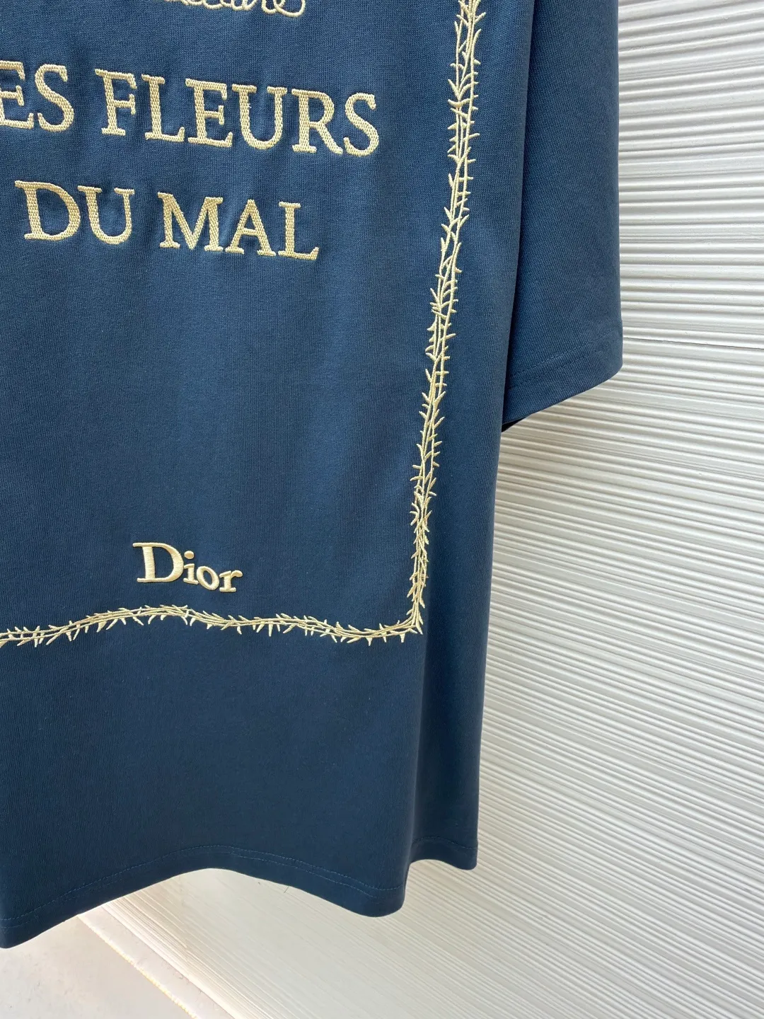 Dior thorn embroidery round neck short sleeves ●Original version: purchased and developed by 13939 ●Item number: 1682473-A05 ●Fabric: cotton jersey fabric ●Technology: embroidery production ●Color: blue ●Version: fitted version ●Weight: about 275 grams ●Size: XS-S-M-L ●Description: Made of blue 12-count cotton jersey fabric with a weight of 230g/㎡; the neckline is made of 32-count double-yarn high-weight (350g) ribbing, which uses extremely high density and elasticity to provide solid neckline support for the loose body and prevent deformation. The fabric is medium thick and provides good stiffness and durability. The 12-count yarn is relatively thick, giving the fabric a rustic texture and casual attributes. Fabrics interwoven with plain weave have many buckling points in the yarns, giving the fabric good fastness and wear resistance. The density is moderate, the fabric is thin, flat and stiff. It has good breathability, is softer, more delicate, and has better gloss. Multi-color computer embroidery technology is used to restore the complex details, text, patterns, etc. of the book cover. Based on the high-precision artwork on the cover of the first edition of "Flowers of Evil", white embroidery thread is used to perform high-density embroidery through a combination of flat stitch, satin embroidery, chain embroidery and other stitching methods. With exquisite and textured handicrafts, the artistic details of literary classic covers are vividly reproduced, and the flat image is transformed into a three-dimensional touch and rich layers. The overall wiring is straight and delicate, the fabric is comfortable and soft, and the color is consistent without color difference. It can be matched with the same style to create a fashionable look and control various occasions. Customized accessories, complete with three standards, same style for men and women!