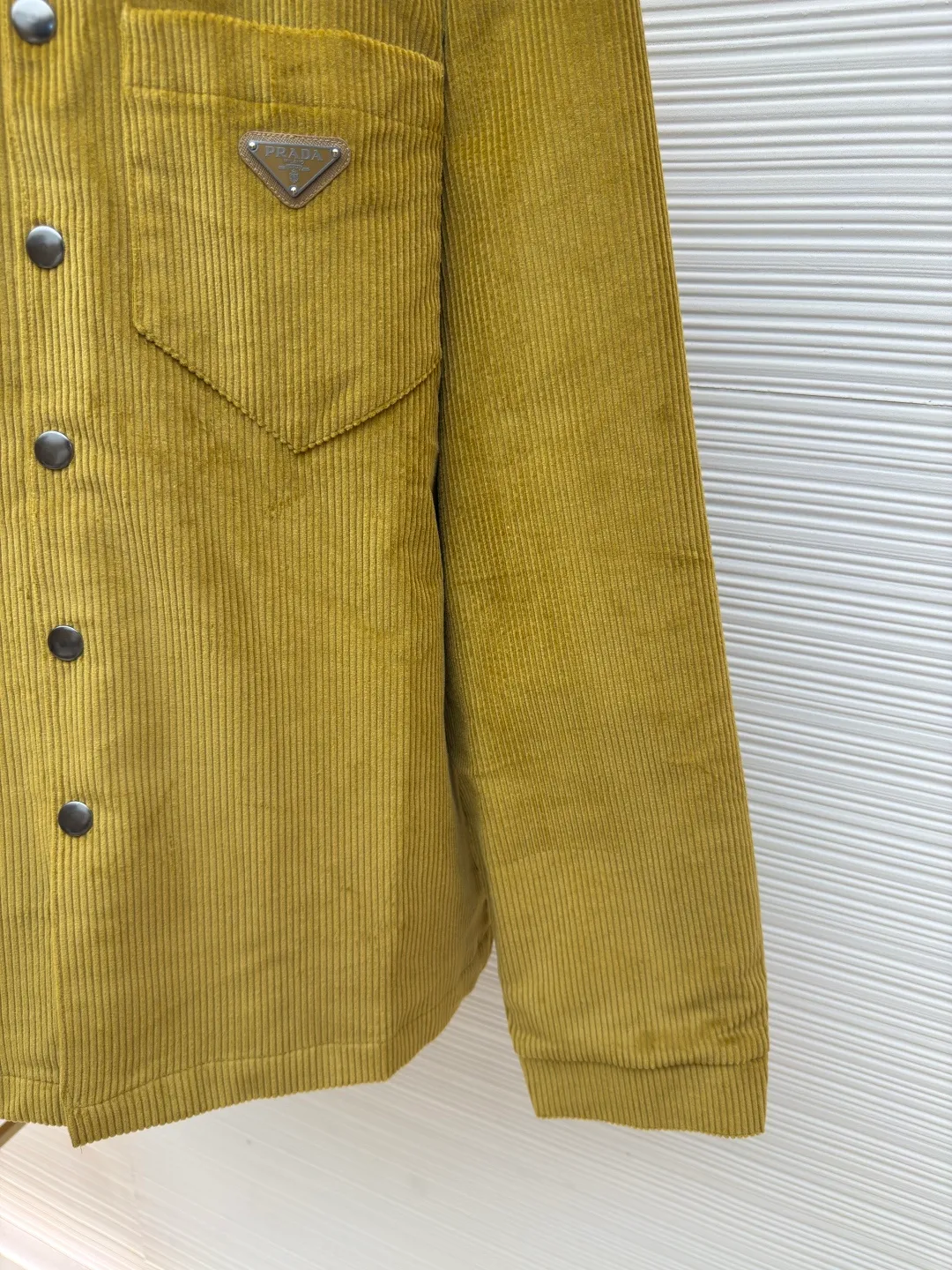 Prada corduroy jacket ●Authentic product: purchased and developed at 16700 ●Item number: 1680049-B70 ●Fabric: corduroy fabric ●Technology: made on positioning cutting machine ●Version: fitted version ●Weight: about 885 grams ●Size: XS-S-M-L ●Description: Made of 100% cotton 8*8 corduroy fabric, dyed with reactive dyes, the color fastness is all solid black, matched with 75D twill nylon lining, the pocket chapter is made of microfiber leather, the aluminum alloy material is embossed with three-dimensional letters on a lathe, and later hand-dotted with black piano paint to seal the glaze. The overall wiring is straight and delicate, the fabric is comfortable and soft, and the color is consistent without color difference. It can be matched with the same style to create a fashionable look and control various occasions. Customized accessories, complete with three standards, same style for men and women!