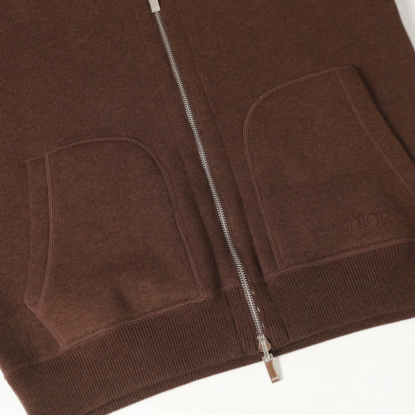 🅿️650 [Original quality] CD/Dior 24FW jacquard double-sided cashmere jacket (brown) The fabric is made of cotton and cashmere blended fabrics, and is made of high-quality wool and cashmere, which is soft and comfortable to the touch. The navy blue cotton blended knitted fabric is carefully crafted using imported machine jacquard technology. One side is decorated with the classic presbyopia logo jacquard pattern, and the other side is a simple white design. It can be worn on both sides. The drawstring hood is paired with metal hardware engraved with the Dior logo, adding refined detail. It features practical patch pockets on the front, and a ribbed hem and cuffs ensure a form-fitting fit. The double zipper with monogram highlights the brand's signature, and the raglan sleeves are cut in a smooth, natural style. The front is embellished with the Dior embroidered logo, and the inside is decorated with Oblique print throughout, with exquisite details. Pair with the matching sports trousers for an elegant and casual look. The whole piece integrates high-end craftsmanship into daily items, showing the brand's exquisite craftsmanship and classic aesthetics. Size:S/M/L/XL