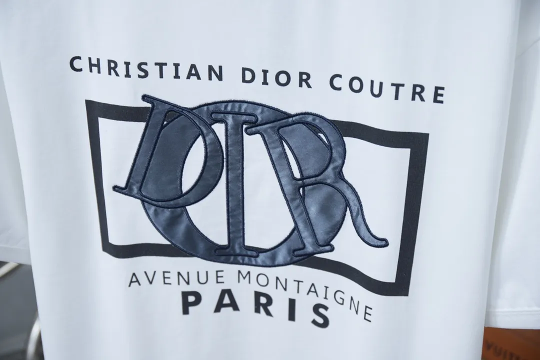 🅿️200 High Quality This T-shirt is decorated with Dior Charm logo print and embroidery, paying tribute to Dior's classic logo. Crafted from white cotton jersey with a classic ribbed crew neck. Casual and versatile, it can be paired with a variety of casual outfits to create a sophisticated look. In the penetration glue printing process, printing dyes and chemical gels are required to ensure that the printing effect is bright and strong. At the same time, in order to obtain better penetration effect, the glue has very good coverage and has a certain gloss. Combined with the patch printing process, patch embroidery, also known as applique embroidery, is a form of embroidery in which other fabrics are cut and sewn onto clothing. The stitching method is used to lock the edges so that the threads or rough areas on the outer edge of the fabric are not exposed, highlighting the styling. S M L XL S M L XL