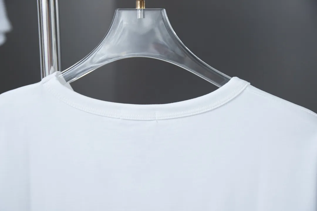 🅿️200 High Quality This T-shirt is decorated with Dior Charm logo print and embroidery, paying tribute to Dior's classic logo. Crafted from white cotton jersey with a classic ribbed crew neck. Casual and versatile, it can be paired with a variety of casual outfits to create a sophisticated look. In the penetration glue printing process, printing dyes and chemical gels are required to ensure that the printing effect is bright and strong. At the same time, in order to obtain better penetration effect, the glue has very good coverage and has a certain gloss. Combined with the patch printing process, patch embroidery, also known as applique embroidery, is a form of embroidery in which other fabrics are cut and sewn onto clothing. The stitching method is used to lock the edges so that the threads or rough areas on the outer edge of the fabric are not exposed, highlighting the styling. S M L XL S M L XL