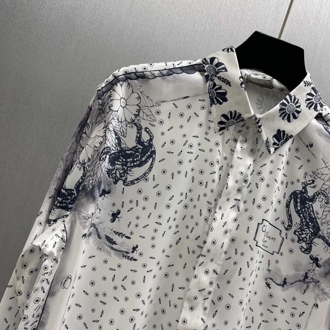 🅿️460 🧧CD Yiyun blue and white style shirt SIZE: S-XL This village shirt comes from the DIOR AND HYLTON NEL joint series, showing an interpretation of the artist's work. Crafted from white mulberry silk twill fabric, it features an oversized fit and a hidden button closure. The style is fashionable and can be paired with other pieces from the limited series.