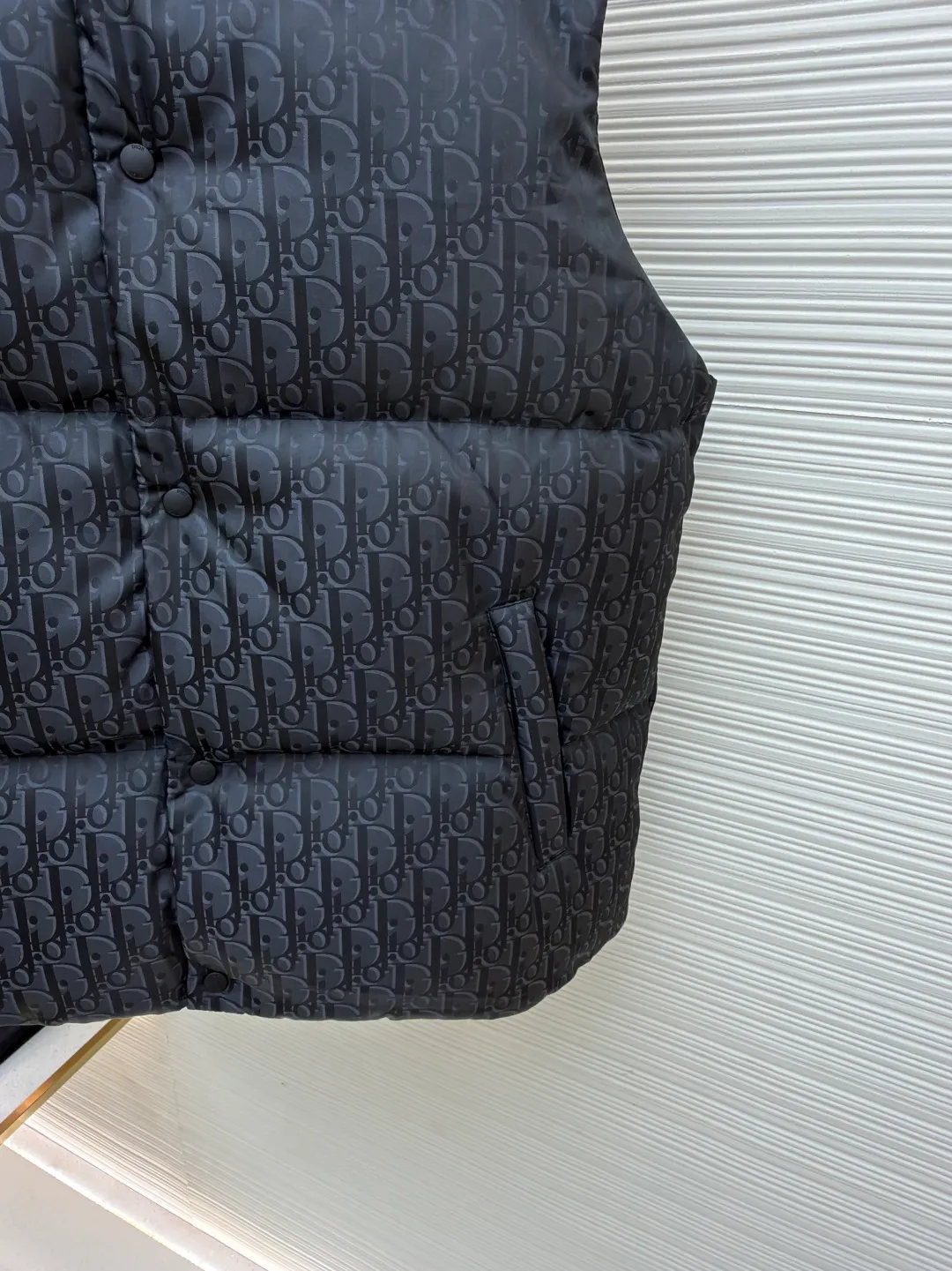 Dior 25ss jacquard all-over printed down vest ●Original version: purchased and developed by 16504 ●Item number: 1681648-B90 ●Fabric: white duck down fabric ●Technology: jacquard production ●Color: black ●Version: fitted version ●Weight: about 545 grams ●Size: 46-48-50-52 ●Description: The fabric adopts scientific jacquard technology: laser jacquard technology is applied to the fabric to make the whole piece of clothing uneven and more three-dimensional. This technology not only improves the visual effect of the fabric, but also enhances its durability and comfort. Custom-woven high-density satin nylon material, combined with dark jacquard weaving, makes the down vest extremely waterproof, anti-fouling, and dust-proof. This ensures that the vest will look and perform well in inclement weather. Oblique printing is applied to fabrics through precise printing technology and blends perfectly with the fabrics, presenting a low-key and luxurious visual effect. High-quality 90% white duck down is used as the filling, and it has been strictly processed and screened to ensure the fluffiness and warmth of the down. Evenly fill the down into the inner bladder of the vest and fix it by sewing and taping. Detailed processing is done on the collar, cuffs, hem and other parts of the vest to improve the practicality and beauty of the vest. At the same time, the vests are ironed and inspected to ensure that the product quality meets the standards. The overall wiring is straight and delicate, the fabric is comfortable and soft, and the color is consistent without color difference. It can be matched with the same style to create a fashionable look and control various occasions. Customized accessories, complete with three standards, same style for men and women!