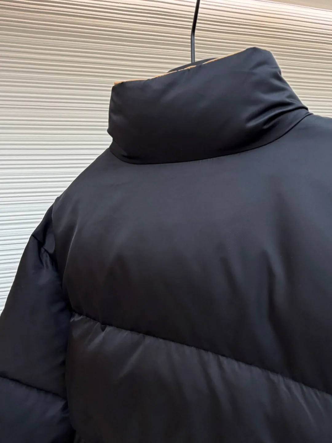 Prada logo stand collar down jacket ●Item number: 1681794-C75 ●Material: white duck down fabric ●Technology: mechanical down filling ●Color: black ●Version: fitted version ●Weight: about 855 grams ●Size: S-M-L-XL ●Description: The recycled nylon fabric made of 100% nylon is woven into a tight and tough fabric through advanced textile technology. The strength of the frame is increased to effectively block the invasion of cold wind and lock the warm air generated by the down layer. After a tight weaving process and special treatment, it is waterproof and windproof. The surface forms a certain lotus leaf effect. It is also anti-wrinkle and not easy to deform, making it easy for daily care. The inner lining is made of caramel brown nylon fabric woven from 100% polyamide. When folded, it creates a strong color contrast, just like the molten gold of the setting sun pouring into the deep night sky. Polyamide fiber is known for its extremely high strength and excellent skin-friendly feel. It feels silky smooth and avoids the friction and discomfort that may occur when wearing heavy underwear. It works together with the outer layer of nylon to create a breathable, temperature-locking, and extremely comfortable microclimate environment, allowing warmth and care to be online at all times without feeling stuffy or restrictive. It uses 90 white duck down with a fill power of 220g to ensure excellent thermal insulation performance. After the velvet has been strictly screened and processed, it is not easy to drill. The 6cm tall stand-up collar fits the neck line without being oppressive, and is as warm as a "second skin" in the cold wind. The junction between the collar and the zipper adopts a bevel splicing process to avoid the rigid feeling of traditional stand-up collars and make it more flexible when you turn your head. The hem has built-in metal adjustment buckles on both sides. You can gently pull it down to tighten the waistline, and lift it up to restore the loose silhouette - it is neat and slim when commuting, and it is free and unrestrained when outdoors. The metal surface of the adjustment buckle is treated with PVD coating, which is wear-resistant and corrosion-resistant, and will last forever. The overall wiring is straight and delicate, the fabric is comfortable and soft, and the color is consistent without color difference. It can be matched with the same style to create a fashionable look and control various occasions. Customized accessories, complete with three standards, same style for men and women!