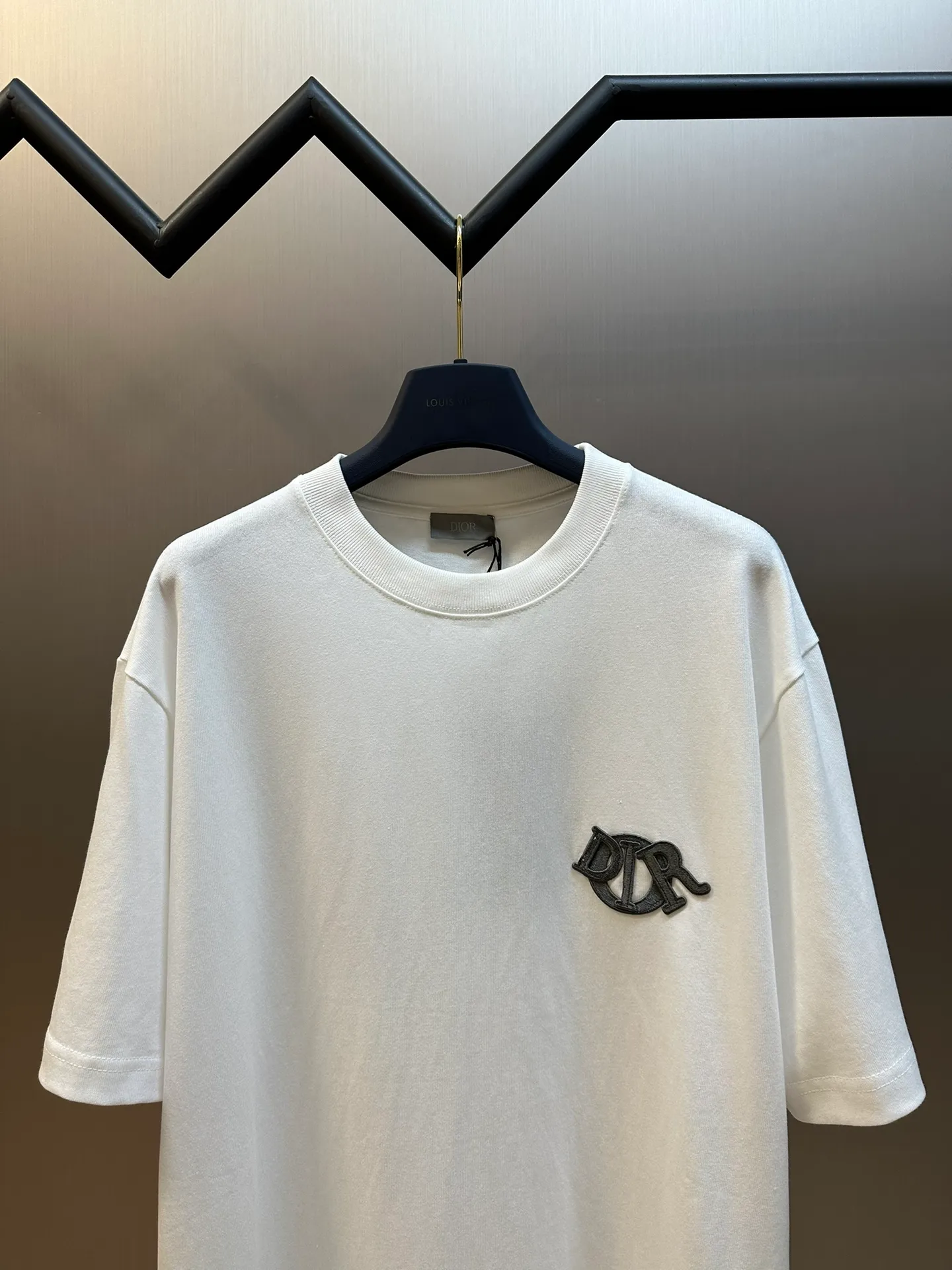 🅿️260 Dior patch letter short sleeves are made of pure cotton 12S fine cotton plain weave, weight 230g. The front is decorated with contrasting logo patches and small embroidered stamps, forming a decorative and iconic embroidery product. The logo is made of imported custom-made embroidery thread, which is dyed with lustrous mercerized embroidery thread, giving it a uniform and glossy finish. The exquisite embroidery machine combines complex embroidery needlework and fine detail processing to create a three-dimensional micro-relief embroidery effect; it is also highly durable and wear-resistant.  The standard round neck and short-sleeved version has a rounded arc neckline, which is suitable for various face shapes and body shapes; the sleeve length is moderate and ends just above the elbow, showing a smart and neat image. The slim fit can show off the wearer's body curves without sacrificing comfort. The collar, cuffs, hem and other parts are all sewn with fine double-needle stitching.  size：xs s m l