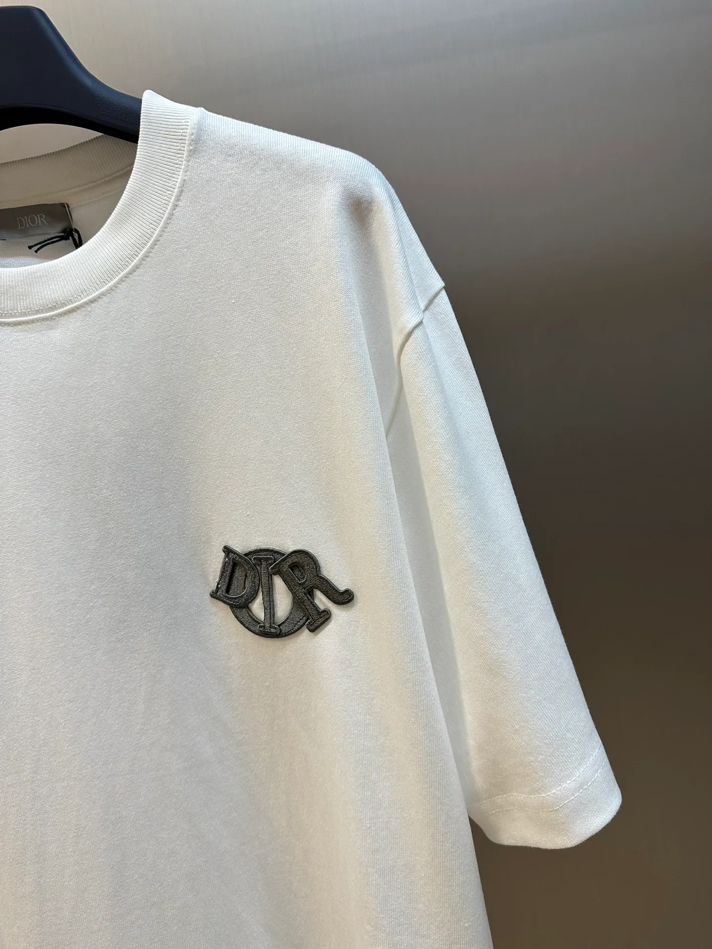 🅿️260 Dior patch letter short sleeves are made of pure cotton 12S fine cotton plain weave, weight 230g. The front is decorated with contrasting logo patches and small embroidered stamps, forming a decorative and iconic embroidery product. The logo is made of imported custom-made embroidery thread, which is dyed with lustrous mercerized embroidery thread, giving it a uniform and glossy finish. The exquisite embroidery machine combines complex embroidery needlework and fine detail processing to create a three-dimensional micro-relief embroidery effect; it is also highly durable and wear-resistant.  The standard round neck and short-sleeved version has a rounded arc neckline, which is suitable for various face shapes and body shapes; the sleeve length is moderate and ends just above the elbow, showing a smart and neat image. The slim fit can show off the wearer's body curves without sacrificing comfort. The collar, cuffs, hem and other parts are all sewn with fine double-needle stitching.  size：xs s m l