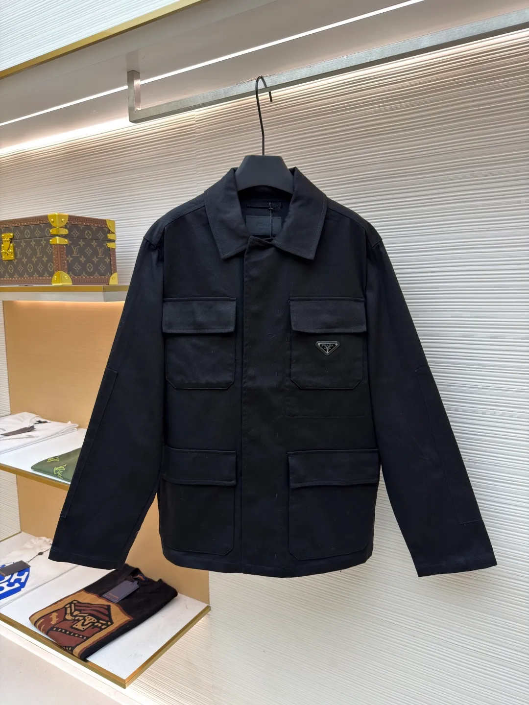 PRADA cotton work style jacket ●Original version: Purchased and developed by 14803 ●Item number: 1680864-B90 ●Fabric: nylon fabric ●Technology: Made on positioning cutting machine ●Version: fitted version ●Weight: about 760 grams ●Size: S-M-L-XL ●Description: The fabric is constructed with 45° diagonal warp and weft interweaving, and the closely arranged cotton yarns form a natural three-dimensional texture, giving it a practical base that is anti-wrinkle and wear-resistant. At the same time, the matte texture echoes the rough aesthetics of workwear style. It retains the natural skin-friendliness and sweat-absorbing ability of cotton fiber, while taking into account warmth and breathability. Utilizing the natural stiffness of the fabric, double-layer cotton yarn is used to reinforce the shoulder seams to create a sculptural wide shoulder silhouette and avoid softness and deformation. Invisible thread strips are embedded in the cuffs to ensure freedom of movement. Through low-temperature pressing and the natural hardness of twill fabric, a 30-degree stiffening angle is created to make the neckline fit the curve of the neck and improve wearing comfort. Abandoning the traditional lining, the stiffness of the fabric itself is used to shape the silhouette, reducing redundant layers while improving breathability. Hidden button closure and straight bottom hem design enhance the tough temperament and balance the loose fit, avoiding a bloated look. Symmetrical flap patch pockets enhance practicality, and the three-dimensional silhouette adds a sense of hierarchy. Tight stitching at the edges makes the bag sturdy while adding beauty. The overall wiring is straight and delicate, the fabric is comfortable and soft, and the color is consistent without color difference. It can be matched with the same style to create a fashionable look and control various occasions. Customized accessories, complete with three standards, same style for men and women!