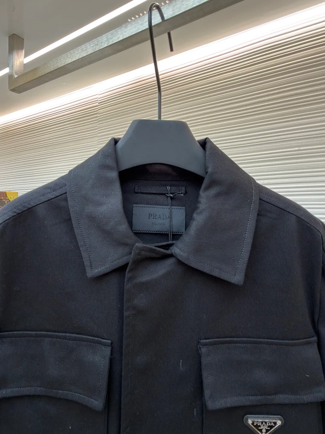 PRADA cotton work style jacket ●Original version: Purchased and developed by 14803 ●Item number: 1680864-B90 ●Fabric: nylon fabric ●Technology: Made on positioning cutting machine ●Version: fitted version ●Weight: about 760 grams ●Size: S-M-L-XL ●Description: The fabric is constructed with 45° diagonal warp and weft interweaving, and the closely arranged cotton yarns form a natural three-dimensional texture, giving it a practical base that is anti-wrinkle and wear-resistant. At the same time, the matte texture echoes the rough aesthetics of workwear style. It retains the natural skin-friendliness and sweat-absorbing ability of cotton fiber, while taking into account warmth and breathability. Utilizing the natural stiffness of the fabric, double-layer cotton yarn is used to reinforce the shoulder seams to create a sculptural wide shoulder silhouette and avoid softness and deformation. Invisible thread strips are embedded in the cuffs to ensure freedom of movement. Through low-temperature pressing and the natural hardness of twill fabric, a 30-degree stiffening angle is created to make the neckline fit the curve of the neck and improve wearing comfort. Abandoning the traditional lining, the stiffness of the fabric itself is used to shape the silhouette, reducing redundant layers while improving breathability. Hidden button closure and straight bottom hem design enhance the tough temperament and balance the loose fit, avoiding a bloated look. Symmetrical flap patch pockets enhance practicality, and the three-dimensional silhouette adds a sense of hierarchy. Tight stitching at the edges makes the bag sturdy while adding beauty. The overall wiring is straight and delicate, the fabric is comfortable and soft, and the color is consistent without color difference. It can be matched with the same style to create a fashionable look and control various occasions. Customized accessories, complete with three standards, same style for men and women!
