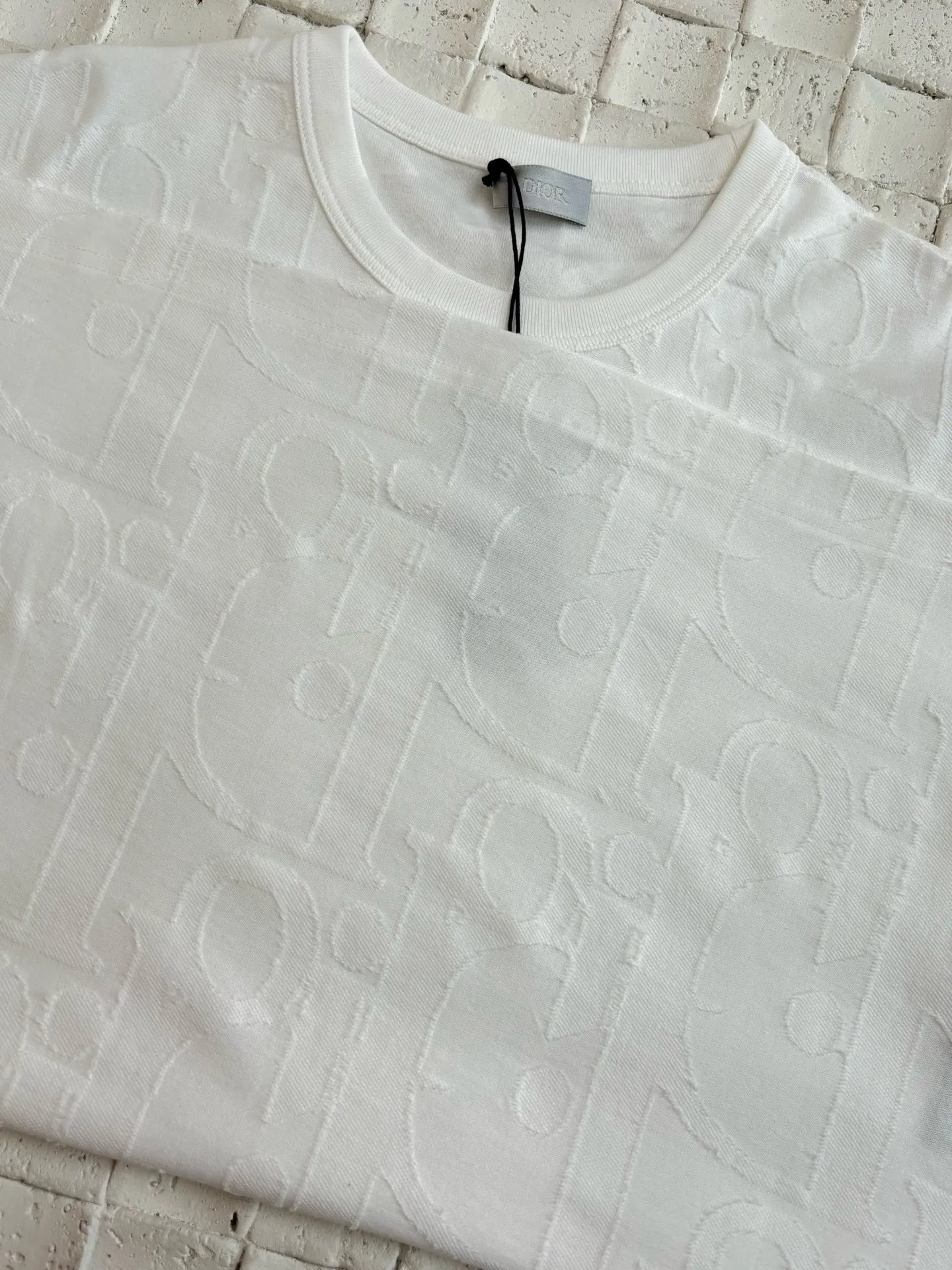 🅿️296 Dio*/Dior 25Ss new line-cut jacquard round-neck short-sleeved T-shirt. Pure cotton plain weave fabric, woven with 32S double-ply pure cotton yarn. The fabric has high abrasion resistance while retaining the moisture absorption and breathability of pure cotton. The plain weave has a tight structure and a smooth surface, but it feels relatively stiff and supports the stiffness of the version. Jacquard pattern, line-cut jacquard technology, full-width Oblique jacquard pattern The relief effect is formed through the deep integration of full-width jacquard and shearing process. The jacquard structure provides a three-dimensional skeleton, and the shearing process strengthens the local texture. Electronic jacquard machine weaves complex patterns on the entire fabric, forming a three-dimensional concave and convex texture to achieve the integration of texture and pattern. The raised jacquard is directionally sheared to form a relief effect, enhancing the tactile level and visual contrast. Size: S/M/L/XL