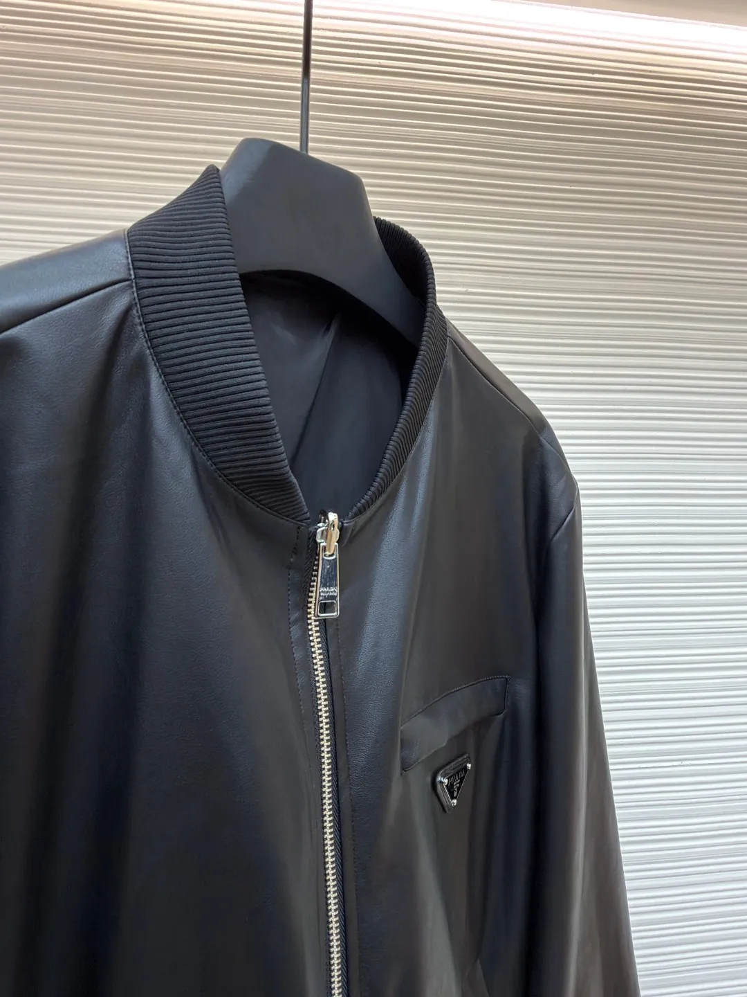 Prada reversible leather plain jacket ●Item number: 1681168-C65 ●Fabric: Leather lambskin fabric ●Technology: Ergonomic three-dimensional cutting ●Color: black ●Version: Fitted version ●Weight: about 970 grams ●Size: 46-48-50-52 ●Description: Customized Leather lambskin and rhyme-hole silky plain fabric, natural texture, natural luster, comfortable and close to the skin Double-sided charm, one garment for multiple enjoyments. On one side, the distinctive leather shows the noble texture, while on the other side, the simple plain grain interprets the low-key connotation. Clean lines and simple textures exude a sense of luxury from the inside out. The iconic enameled triangular metal logos are respectively embellished to highlight the elegance and nobility of the brand. It is highly recognizable. The two-sided transformation is wonderful and reflects each other. It unlocks a new dimension of fashion and uses imported infrared machines to locate the "Prada triangle logo" for more accurate positioning. Firm stone, ergonomic three-dimensional cutting, return to traditional craftsmanship through segmentation, folding, shrinking, and stretching techniques. The so-called slow work produces fine work, which is the respect for the material and the pursuit of feel. The workmanship is complex and tedious. Slow timeliness and high loss. The template machine opens the bag. The preset template guides the position, shape and size of the bag. The accuracy ensures the quality of the bag opening effect. The overall wiring is straight and delicate, the fabric is comfortable and soft, and the color is consistent without color difference. It can be matched with the same style to create a fashionable look and control various occasions. Customized accessories, complete with three standards, same style for men and women!