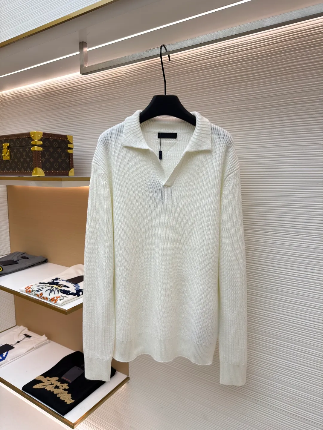 PRADA triangle logo seagull collar knitted sweater ●Item number: 1681464-A75 ●Fabric: 100% cotton ●Technology: knitted ●Color: white ●Version: Fitted version ●Weight: about 820 grams ●Size: S-M-L-XL ●Description: This sweater uses Polo collar knitting technology, with a crisp and stylish neckline, blending leisure and sophistication. Using thick needle texture weaving technology, the body texture is clear and rich in texture, creating a retro and simple style. In terms of details, the precise splicing process of the collar and placket ensures neat and natural stitching, ensuring the neatness of the silhouette; the rib knitting process of the cuffs and hem has moderate elasticity, which not only fits the body shape but also enhances the comfort of wearing. Made of high-quality knitted fabric and finely woven, it is skin-friendly, breathable and has a crisp silhouette. From the design of the neckline to the presentation of texture, every craftsmanship reflects the pursuit of classic styles and delicate workmanship. It is a knitted item that combines daily practicality with style. The overall wiring is straight and delicate, the fabric is comfortable and soft, and the color is consistent without color difference. It can be matched with the same style to create a fashionable look and control various occasions. Customized accessories, complete with three standards, same style for men and women!