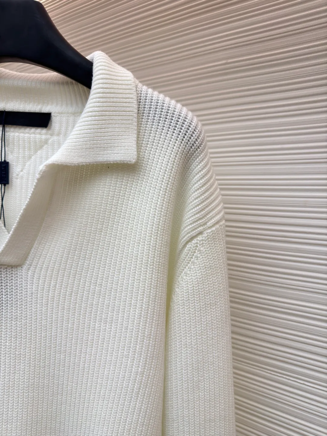 PRADA triangle logo seagull collar knitted sweater ●Item number: 1681464-A75 ●Fabric: 100% cotton ●Technology: knitted ●Color: white ●Version: Fitted version ●Weight: about 820 grams ●Size: S-M-L-XL ●Description: This sweater uses Polo collar knitting technology, with a crisp and stylish neckline, blending leisure and sophistication. Using thick needle texture weaving technology, the body texture is clear and rich in texture, creating a retro and simple style. In terms of details, the precise splicing process of the collar and placket ensures neat and natural stitching, ensuring the neatness of the silhouette; the rib knitting process of the cuffs and hem has moderate elasticity, which not only fits the body shape but also enhances the comfort of wearing. Made of high-quality knitted fabric and finely woven, it is skin-friendly, breathable and has a crisp silhouette. From the design of the neckline to the presentation of texture, every craftsmanship reflects the pursuit of classic styles and delicate workmanship. It is a knitted item that combines daily practicality with style. The overall wiring is straight and delicate, the fabric is comfortable and soft, and the color is consistent without color difference. It can be matched with the same style to create a fashionable look and control various occasions. Customized accessories, complete with three standards, same style for men and women!