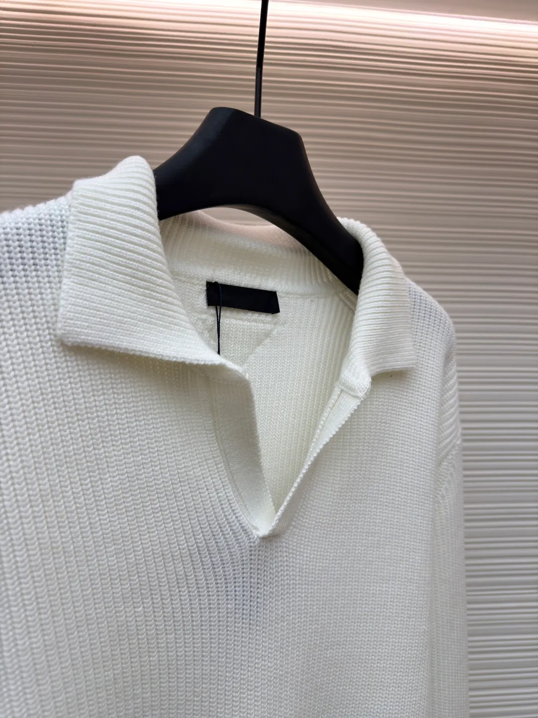 PRADA triangle logo seagull collar knitted sweater ●Item number: 1681464-A75 ●Fabric: 100% cotton ●Technology: knitted ●Color: white ●Version: Fitted version ●Weight: about 820 grams ●Size: S-M-L-XL ●Description: This sweater uses Polo collar knitting technology, with a crisp and stylish neckline, blending leisure and sophistication. Using thick needle texture weaving technology, the body texture is clear and rich in texture, creating a retro and simple style. In terms of details, the precise splicing process of the collar and placket ensures neat and natural stitching, ensuring the neatness of the silhouette; the rib knitting process of the cuffs and hem has moderate elasticity, which not only fits the body shape but also enhances the comfort of wearing. Made of high-quality knitted fabric and finely woven, it is skin-friendly, breathable and has a crisp silhouette. From the design of the neckline to the presentation of texture, every craftsmanship reflects the pursuit of classic styles and delicate workmanship. It is a knitted item that combines daily practicality with style. The overall wiring is straight and delicate, the fabric is comfortable and soft, and the color is consistent without color difference. It can be matched with the same style to create a fashionable look and control various occasions. Customized accessories, complete with three standards, same style for men and women!