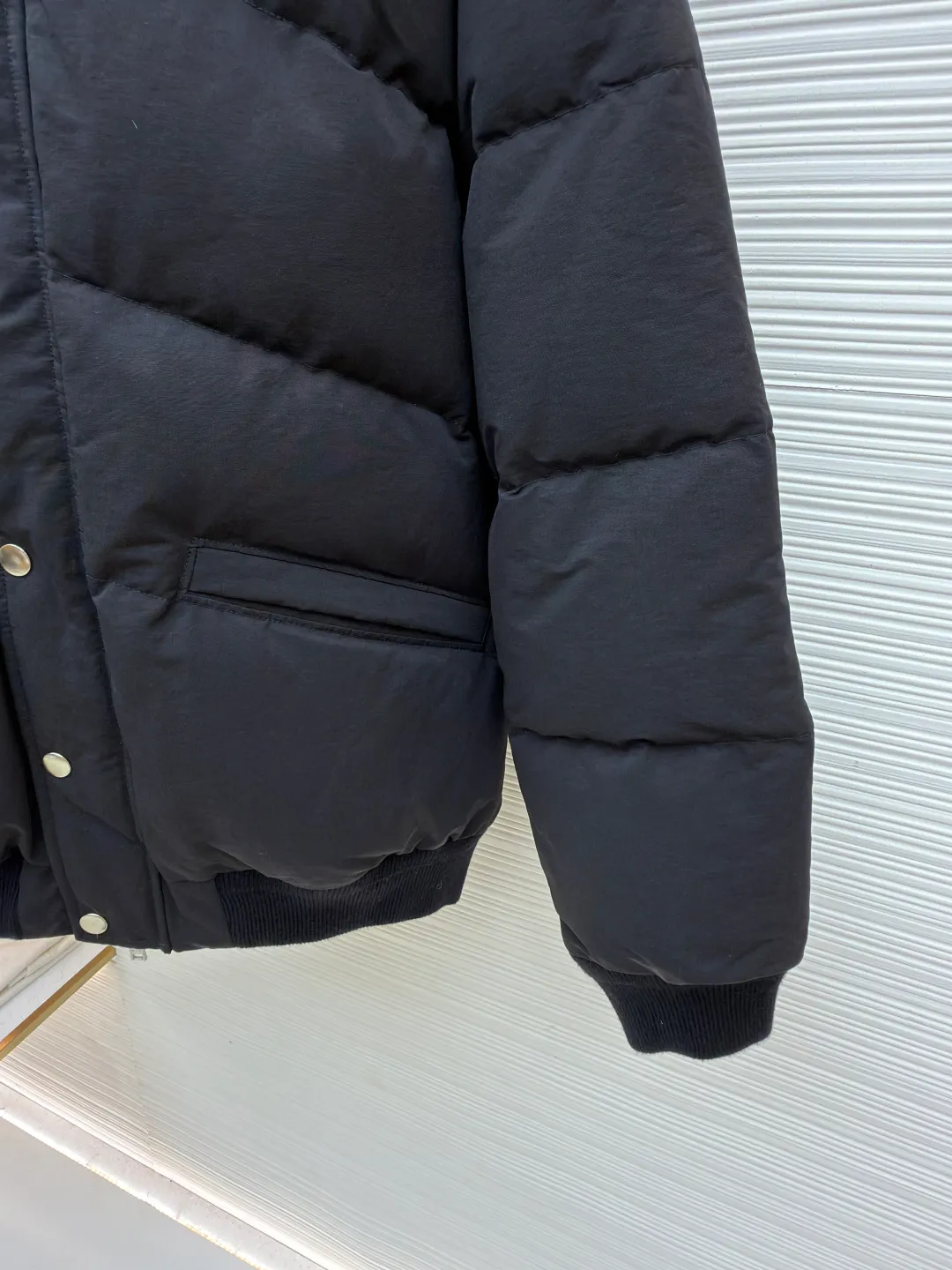 Prada down jacket with triangle stand collar ●Original version: purchased and developed by 15436 ●Item number: 1681713-D15 ●Fabric: white duck down fabric ●Technology: mechanical down filling ●Color: black ●Version: fitted version ●Weight: about 1105 grams ●Size: S-M-L-XL ●Description: Selected high-count poplin fabric, showing a unique matte texture, high-count and high-density weaving with fine warp yarns and thick weft yarns. The unique cross texture on the surface is stiffer than ordinary cotton and more skin-friendly than nylon. Filled with 90% selected white duck down and weighing 230g, it ensures fluffiness, quick rebound, lightness and warmth. The quilting stitches are sewn in a diagonal direction at an angle of about 65 degrees, and the diagonal lines are arranged in parallel. The fabric and filling are planned into different functional areas, and the quilting stitches in each partition are relatively independent. This allows the finished product to produce a larger deformation space along the diagonal direction when stretched and pressed, making it less likely to tighten and break. The diamond grid has a strong sense of direction and movement, and the visual effect is rich, modern and advanced. The overall wiring is straight and delicate, the fabric is comfortable and soft, and the color is consistent without color difference. It can be matched with the same style to create a fashionable look and control various occasions. Customized accessories, complete with three standards, same style for men and women!
