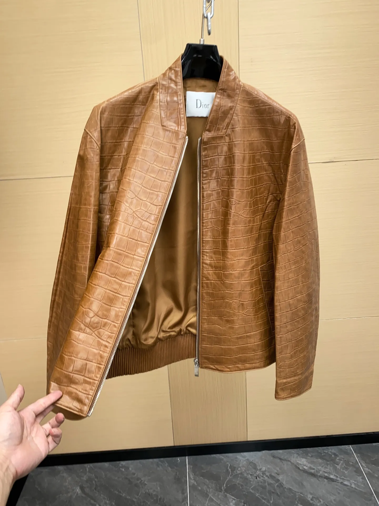 🅿️3100 DIOR Dior's new men's sheepskin jacket for autumn and winter 2025, reshaping autumn and winter style. On the fashion stage, Dior has always been the trend leader. In the autumn and winter of 2025, Dior's new men's sheepskin jacket makes a shocking debut, bringing the ultimate experience to men who pursue quality and style.   The jacket is made of imported brown sheepskin. Its unique color is deep and full of charm, like an elegant poem that has accumulated over time, highlighting the mature and stable temperament of men. This high-quality sheepskin not only looks charming, but also feels soft and delicate. Every time you touch it, you can feel the luxurious texture brought by the top material. It also has good breathability and wear resistance, ensuring that it is comfortable to wear in various occasions.   The design with crocodile print all over the body is the finishing touch. The crocodile pattern symbolizes strength and wildness, injecting unique fashion tension into the jacket, making the wearer stand out from the crowd. Every texture has been carefully suppressed, delicate and clear, showing a lifelike three-dimensional effect, interpreting Dior's persistent pursuit of craftsmanship.   The short version is a precise grasp of modern fashion. It breaks the traditional constraints and cleverly optimizes body proportions. Even men with average figures can instantly have a tall and straight posture when wearing it, showing a neat and capable temperament. Whether it is paired with a simple white T-shirt and jeans for casual daily use, or worn with a shirt and trousers for a business event, it can be perfectly adapted and can easily handle various occasions.   The new products of the season have arrived in the store. We sincerely invite you to try them out and experience the unique charm of Dior's new 2025 autumn and winter men's sheepskin jackets.  Code number: 48-56