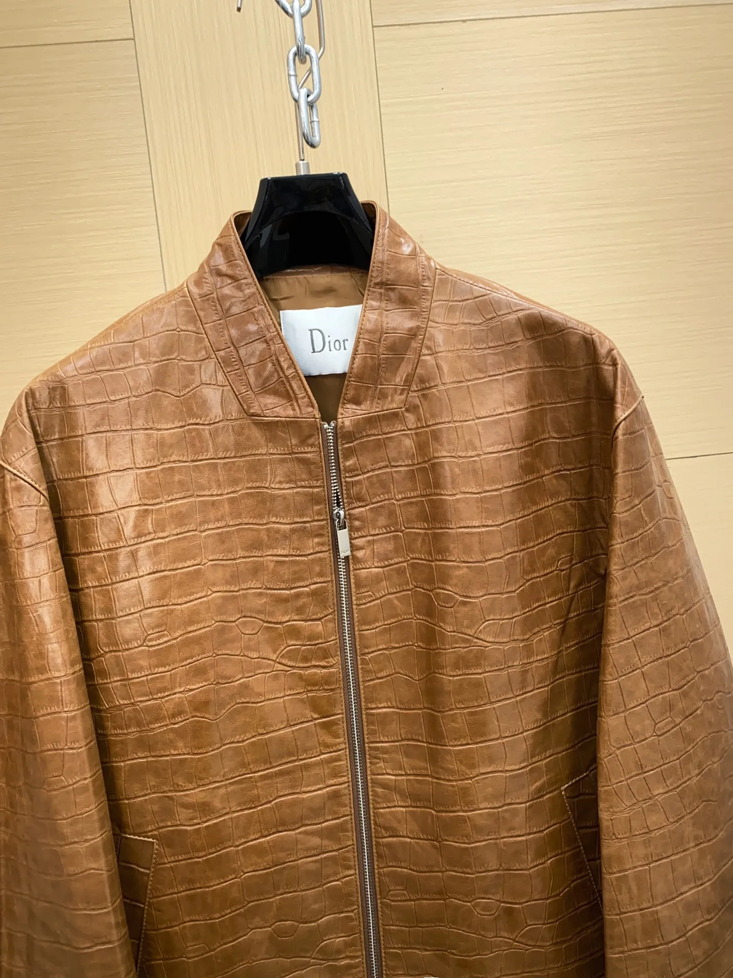 🅿️3100 DIOR Dior's new men's sheepskin jacket for autumn and winter 2025, reshaping autumn and winter style. On the fashion stage, Dior has always been the trend leader. In the autumn and winter of 2025, Dior's new men's sheepskin jacket makes a shocking debut, bringing the ultimate experience to men who pursue quality and style.   The jacket is made of imported brown sheepskin. Its unique color is deep and full of charm, like an elegant poem that has accumulated over time, highlighting the mature and stable temperament of men. This high-quality sheepskin not only looks charming, but also feels soft and delicate. Every time you touch it, you can feel the luxurious texture brought by the top material. It also has good breathability and wear resistance, ensuring that it is comfortable to wear in various occasions.   The design with crocodile print all over the body is the finishing touch. The crocodile pattern symbolizes strength and wildness, injecting unique fashion tension into the jacket, making the wearer stand out from the crowd. Every texture has been carefully suppressed, delicate and clear, showing a lifelike three-dimensional effect, interpreting Dior's persistent pursuit of craftsmanship.   The short version is a precise grasp of modern fashion. It breaks the traditional constraints and cleverly optimizes body proportions. Even men with average figures can instantly have a tall and straight posture when wearing it, showing a neat and capable temperament. Whether it is paired with a simple white T-shirt and jeans for casual daily use, or worn with a shirt and trousers for a business event, it can be perfectly adapted and can easily handle various occasions.   The new products of the season have arrived in the store. We sincerely invite you to try them out and experience the unique charm of Dior's new 2025 autumn and winter men's sheepskin jackets.  Code number: 48-56