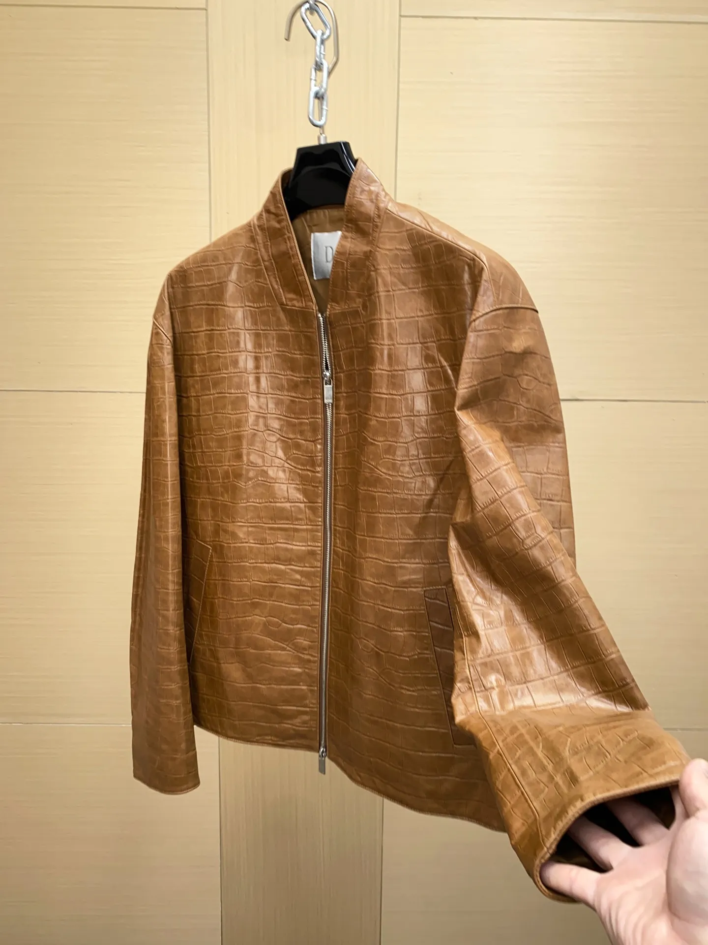 🅿️3100 DIOR Dior's new men's sheepskin jacket for autumn and winter 2025, reshaping autumn and winter style. On the fashion stage, Dior has always been the trend leader. In the autumn and winter of 2025, Dior's new men's sheepskin jacket makes a shocking debut, bringing the ultimate experience to men who pursue quality and style.   The jacket is made of imported brown sheepskin. Its unique color is deep and full of charm, like an elegant poem that has accumulated over time, highlighting the mature and stable temperament of men. This high-quality sheepskin not only looks charming, but also feels soft and delicate. Every time you touch it, you can feel the luxurious texture brought by the top material. It also has good breathability and wear resistance, ensuring that it is comfortable to wear in various occasions.   The design with crocodile print all over the body is the finishing touch. The crocodile pattern symbolizes strength and wildness, injecting unique fashion tension into the jacket, making the wearer stand out from the crowd. Every texture has been carefully suppressed, delicate and clear, showing a lifelike three-dimensional effect, interpreting Dior's persistent pursuit of craftsmanship.   The short version is a precise grasp of modern fashion. It breaks the traditional constraints and cleverly optimizes body proportions. Even men with average figures can instantly have a tall and straight posture when wearing it, showing a neat and capable temperament. Whether it is paired with a simple white T-shirt and jeans for casual daily use, or worn with a shirt and trousers for a business event, it can be perfectly adapted and can easily handle various occasions.   The new products of the season have arrived in the store. We sincerely invite you to try them out and experience the unique charm of Dior's new 2025 autumn and winter men's sheepskin jackets.  Code number: 48-56