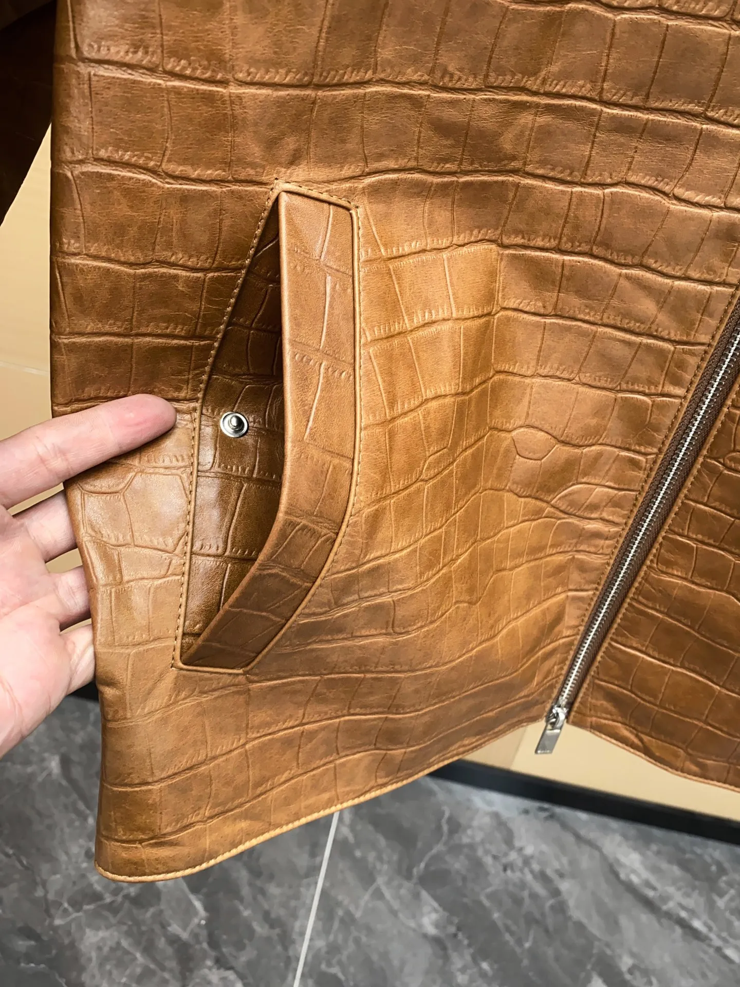 🅿️3100 DIOR Dior's new men's sheepskin jacket for autumn and winter 2025, reshaping autumn and winter style. On the fashion stage, Dior has always been the trend leader. In the autumn and winter of 2025, Dior's new men's sheepskin jacket makes a shocking debut, bringing the ultimate experience to men who pursue quality and style.   The jacket is made of imported brown sheepskin. Its unique color is deep and full of charm, like an elegant poem that has accumulated over time, highlighting the mature and stable temperament of men. This high-quality sheepskin not only looks charming, but also feels soft and delicate. Every time you touch it, you can feel the luxurious texture brought by the top material. It also has good breathability and wear resistance, ensuring that it is comfortable to wear in various occasions.   The design with crocodile print all over the body is the finishing touch. The crocodile pattern symbolizes strength and wildness, injecting unique fashion tension into the jacket, making the wearer stand out from the crowd. Every texture has been carefully suppressed, delicate and clear, showing a lifelike three-dimensional effect, interpreting Dior's persistent pursuit of craftsmanship.   The short version is a precise grasp of modern fashion. It breaks the traditional constraints and cleverly optimizes body proportions. Even men with average figures can instantly have a tall and straight posture when wearing it, showing a neat and capable temperament. Whether it is paired with a simple white T-shirt and jeans for casual daily use, or worn with a shirt and trousers for a business event, it can be perfectly adapted and can easily handle various occasions.   The new products of the season have arrived in the store. We sincerely invite you to try them out and experience the unique charm of Dior's new 2025 autumn and winter men's sheepskin jackets.  Code number: 48-56