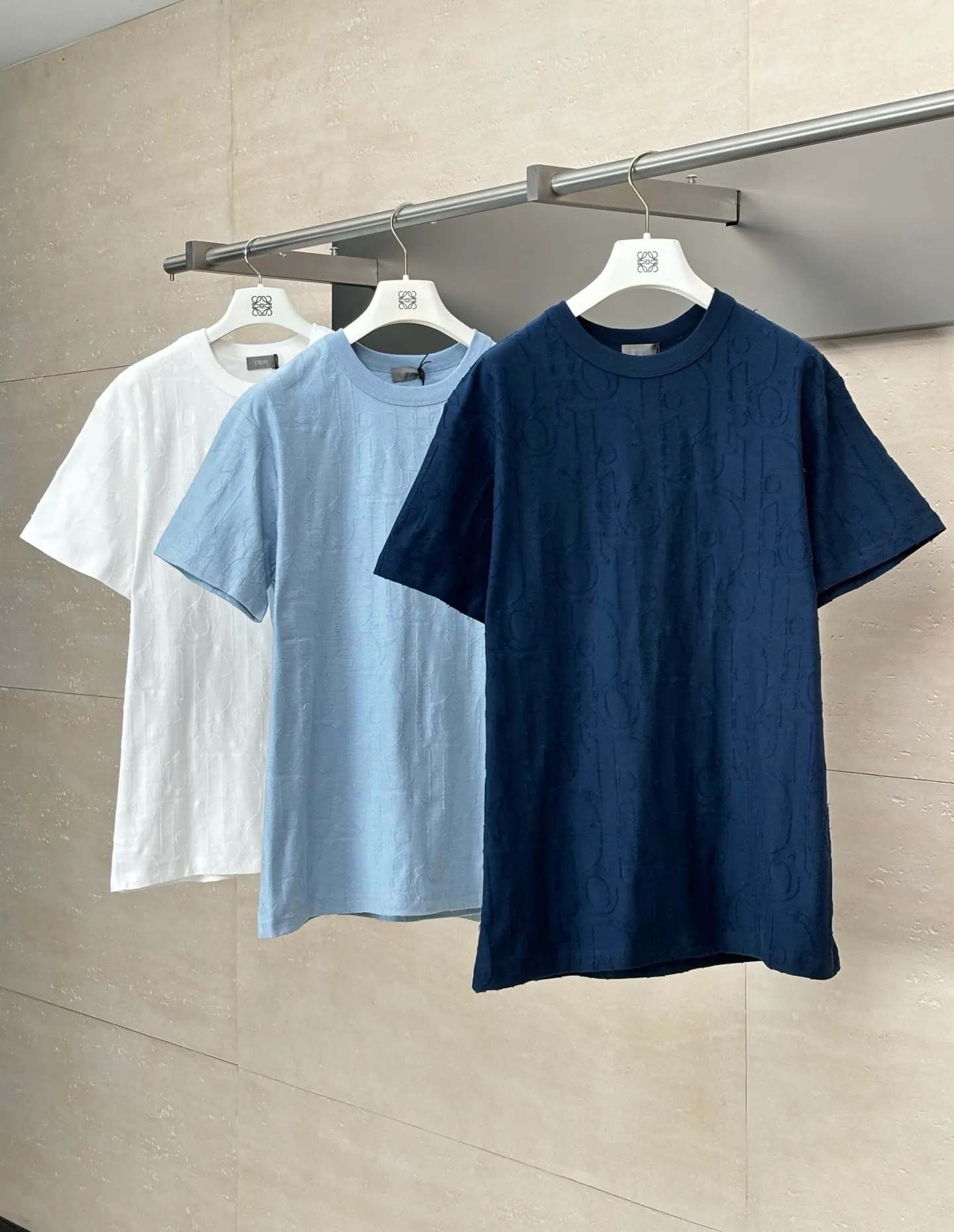 🅿️296 Dio*/Dior 25Ss new line-cut jacquard round-neck short-sleeved T-shirt. Pure cotton plain weave fabric, woven with 32S double-ply pure cotton yarn. The fabric has high abrasion resistance while retaining the moisture absorption and breathability of pure cotton. The plain weave has a tight structure and a smooth surface, but it feels relatively stiff and supports the stiffness of the version. Jacquard pattern, line-cut jacquard technology, full-width Oblique jacquard pattern The relief effect is formed through the deep integration of full-width jacquard and shearing process. The jacquard structure provides a three-dimensional skeleton, and the shearing process strengthens the local texture. Electronic jacquard machine weaves complex patterns on the entire fabric, forming a three-dimensional concave and convex texture to achieve the integration of texture and pattern. The raised jacquard is directionally sheared to form a relief effect, enhancing the tactile level and visual contrast. Size: S/M/L/XL