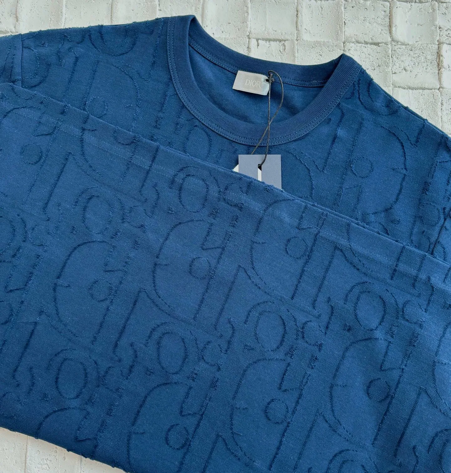 🅿️296 Dio*/Dior 25Ss new line-cut jacquard round-neck short-sleeved T-shirt. Pure cotton plain weave fabric, woven with 32S double-ply pure cotton yarn. The fabric has high abrasion resistance while retaining the moisture absorption and breathability of pure cotton. The plain weave has a tight structure and a smooth surface, but it feels relatively stiff and supports the stiffness of the version. Jacquard pattern, line-cut jacquard technology, full-width Oblique jacquard pattern The relief effect is formed through the deep integration of full-width jacquard and shearing process. The jacquard structure provides a three-dimensional skeleton, and the shearing process strengthens the local texture. Electronic jacquard machine weaves complex patterns on the entire fabric, forming a three-dimensional concave and convex texture to achieve the integration of texture and pattern. The raised jacquard is directionally sheared to form a relief effect, enhancing the tactile level and visual contrast. Size: S/M/L/XL