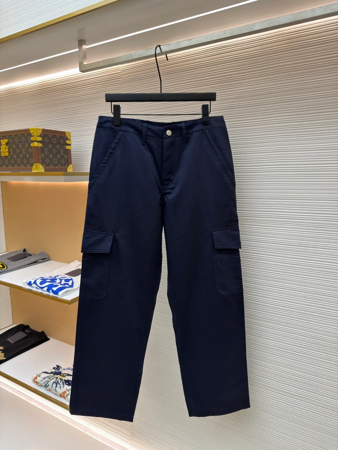 Dior cotton Huardani overalls ●Original version: purchased and developed by 12072 ●Item number: 1682111-B05 ●Fabric: 100% cotton ●Technology: Made on positioning cutting machine ●Color: navy blue ●Version: fitted version ●Weight: about 540 grams ●Size: 46-48-50-52-54-56 ●Description: This Dior SS26 spring men's overalls are made of high-count combed cotton twill fabric. The fabric has been enzyme washed and pre-shrunk to form a crisp and soft texture, and is anti-wrinkle and wear-resistant. The cargo pockets on both sides of the trousers adopt a three-dimensional patch pocket design. The pocket is equipped with a metal zipper. The zipper teeth are treated with electroplating and polishing processes, making them smooth and easy to pull and not easy to oxidize. The bag body is reinforced with double-lane stitching to increase the load-bearing capacity. The waist is equipped with a belt loop and adjustable buckle design. The belt loop is edged with the same fabric, and the buckle is made of alloy material and treated with matte sandblasting, giving it a high-end texture. The crotch adopts classic cross-reinforced stitching, the trousers are hemmed and hemmed, and the overall cut is a straight silhouette. Every splicing is precisely patterned and aligned, and the stitching is neat and detailed, perfectly integrating the practicality of workwear with the craftsmanship aesthetics of Dior's advanced men's wear. The overall wiring is straight and delicate, the fabric is comfortable and soft, and the color is consistent without color difference. It can be matched with the same style to create a fashionable look and control various occasions. Customized accessories, complete with three standards, same style for men and women!