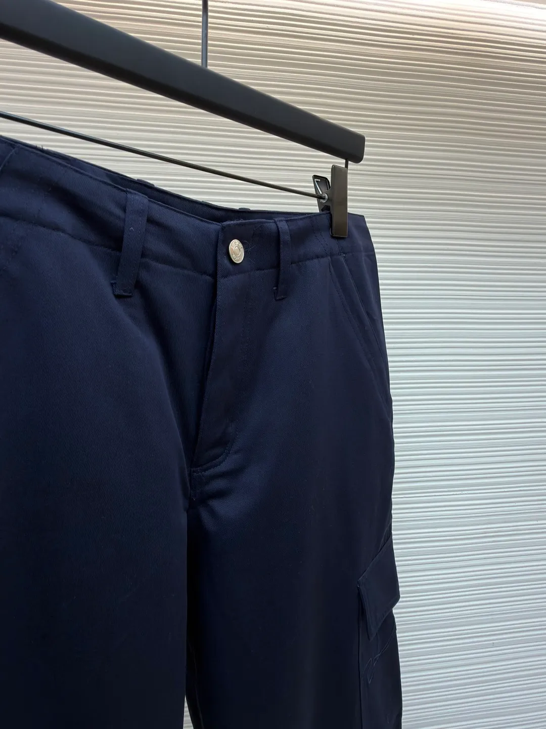 Dior cotton Huardani overalls ●Original version: purchased and developed by 12072 ●Item number: 1682111-B05 ●Fabric: 100% cotton ●Technology: Made on positioning cutting machine ●Color: navy blue ●Version: fitted version ●Weight: about 540 grams ●Size: 46-48-50-52-54-56 ●Description: This Dior SS26 spring men's overalls are made of high-count combed cotton twill fabric. The fabric has been enzyme washed and pre-shrunk to form a crisp and soft texture, and is anti-wrinkle and wear-resistant. The cargo pockets on both sides of the trousers adopt a three-dimensional patch pocket design. The pocket is equipped with a metal zipper. The zipper teeth are treated with electroplating and polishing processes, making them smooth and easy to pull and not easy to oxidize. The bag body is reinforced with double-lane stitching to increase the load-bearing capacity. The waist is equipped with a belt loop and adjustable buckle design. The belt loop is edged with the same fabric, and the buckle is made of alloy material and treated with matte sandblasting, giving it a high-end texture. The crotch adopts classic cross-reinforced stitching, the trousers are hemmed and hemmed, and the overall cut is a straight silhouette. Every splicing is precisely patterned and aligned, and the stitching is neat and detailed, perfectly integrating the practicality of workwear with the craftsmanship aesthetics of Dior's advanced men's wear. The overall wiring is straight and delicate, the fabric is comfortable and soft, and the color is consistent without color difference. It can be matched with the same style to create a fashionable look and control various occasions. Customized accessories, complete with three standards, same style for men and women!