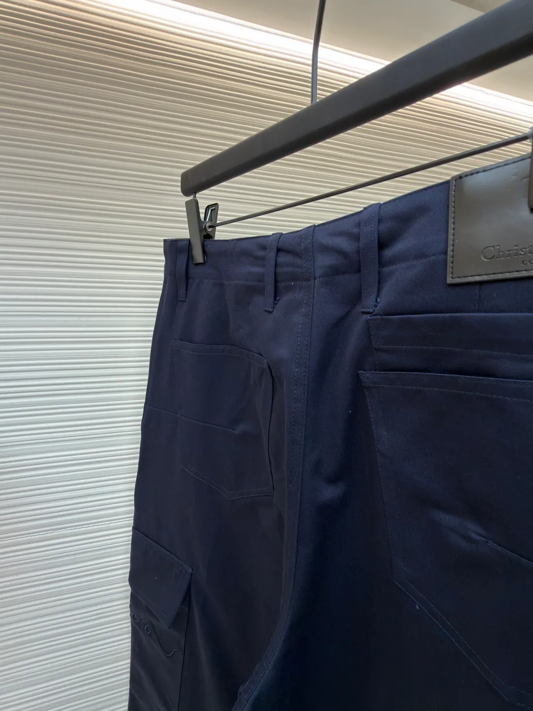 Dior cotton Huardani overalls ●Original version: purchased and developed by 12072 ●Item number: 1682111-B05 ●Fabric: 100% cotton ●Technology: Made on positioning cutting machine ●Color: navy blue ●Version: fitted version ●Weight: about 540 grams ●Size: 46-48-50-52-54-56 ●Description: This Dior SS26 spring men's overalls are made of high-count combed cotton twill fabric. The fabric has been enzyme washed and pre-shrunk to form a crisp and soft texture, and is anti-wrinkle and wear-resistant. The cargo pockets on both sides of the trousers adopt a three-dimensional patch pocket design. The pocket is equipped with a metal zipper. The zipper teeth are treated with electroplating and polishing processes, making them smooth and easy to pull and not easy to oxidize. The bag body is reinforced with double-lane stitching to increase the load-bearing capacity. The waist is equipped with a belt loop and adjustable buckle design. The belt loop is edged with the same fabric, and the buckle is made of alloy material and treated with matte sandblasting, giving it a high-end texture. The crotch adopts classic cross-reinforced stitching, the trousers are hemmed and hemmed, and the overall cut is a straight silhouette. Every splicing is precisely patterned and aligned, and the stitching is neat and detailed, perfectly integrating the practicality of workwear with the craftsmanship aesthetics of Dior's advanced men's wear. The overall wiring is straight and delicate, the fabric is comfortable and soft, and the color is consistent without color difference. It can be matched with the same style to create a fashionable look and control various occasions. Customized accessories, complete with three standards, same style for men and women!