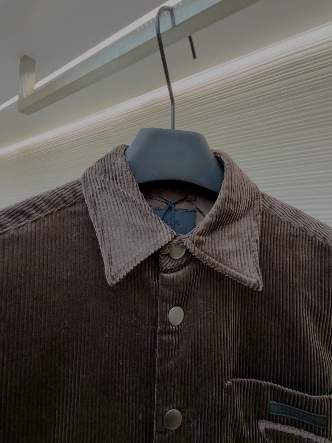 Prada triangle logo corduroy cotton jacket ●Original version: purchased and developed by 10012 ●Item number: 1682236-B90 ●Fabric: corduroy fabric ●Technology: made on positioning cutting machine ●Color: brown ●Version: fitted version ●Weight: about 745 grams ●Size: XS-S-M-L ●Description: This brown corduroy shirt-style jacket is made of high-count combed cotton corduroy fabric. It has been treated with pre-washing water. The fabric velvet is even in thickness, soft and waxy to the touch, and not easy to pill and deform. It also has good drape and wrinkle resistance. The body is cut into a loose shirt silhouette, and the shoulders are designed with natural dropped shoulders. Combined with three-dimensional tailoring technology, the shape is more ergonomic. The placket is made of matte metal snaps, treated with anti-oxidation plating, which makes it high-quality and durable. The triangular patch pocket on the chest is equipped with the brand's metal logo plate, which is fixed with manual caulking and has neat edges. The collar and cuffs are double-layered and reinforced, the sewing stitches are fine and even, and the spacing of each inch of stitches is strictly controlled. The overall workmanship combines practicality and exquisiteness, fully demonstrating the craftsmanship. The overall wiring is straight and delicate, the fabric is comfortable and soft, and the color is consistent without color difference. It can be matched with the same style to create a fashionable look and control various occasions. Customized accessories, complete with three standards, same style for men and women!