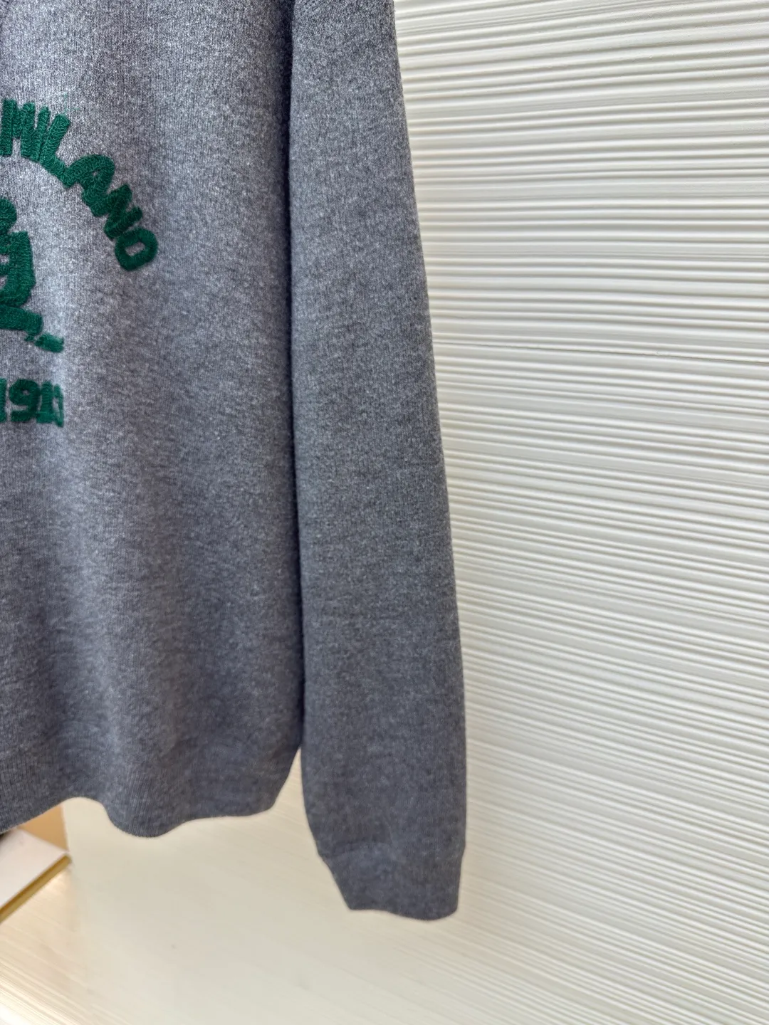Prada music logo embroidered knitted sweater ●Article number: 1680706-A85 ●Fabric: Jersey knitted fabric ●Technology: Knitted embroidery production ●Version: Fitted version ●Weight: about 560 grams ●Size: S-M-L-XL ●Description: The "V-shaped design thread" on the neckline is by no means an ordinary stitch, but a functional and decorative craft. The highlight of chain-style towel embroidery is the special embroidery technique, which uses repeated chain stitches to form a continuous, raised towel-like coil effect pattern that appears on the cloth with a strong three-dimensional effect, soft and fluffy to the touch, and highly recognizable. It presents a terry-like texture, forming an interesting contrast with the smooth underside of the sweater, enriching the visual and tactile layers. The chain structure makes the embroidery not easy to snag or fall off, and has good durability. The collar, cuffs and hem are all ribbed; the excellent lateral elasticity of the ribbed tissue not only ensures that the key parts of the body are firm and not easily deformed, durable and washable, but can also be tightened naturally to outline a neat outline. Its functionality and decoration coexist: it not only prevents the intrusion of cold wind and improves thermal insulation efficiency, but also adds a sense of rhythm in details to the overall simple design, making the shape more crisp. The overall wiring is straight and delicate, the fabric is comfortable and soft, and the color is consistent without color difference. It can be matched with the same style to create a fashionable look and control various occasions. Customized accessories, complete with three standards, same style for men and women!