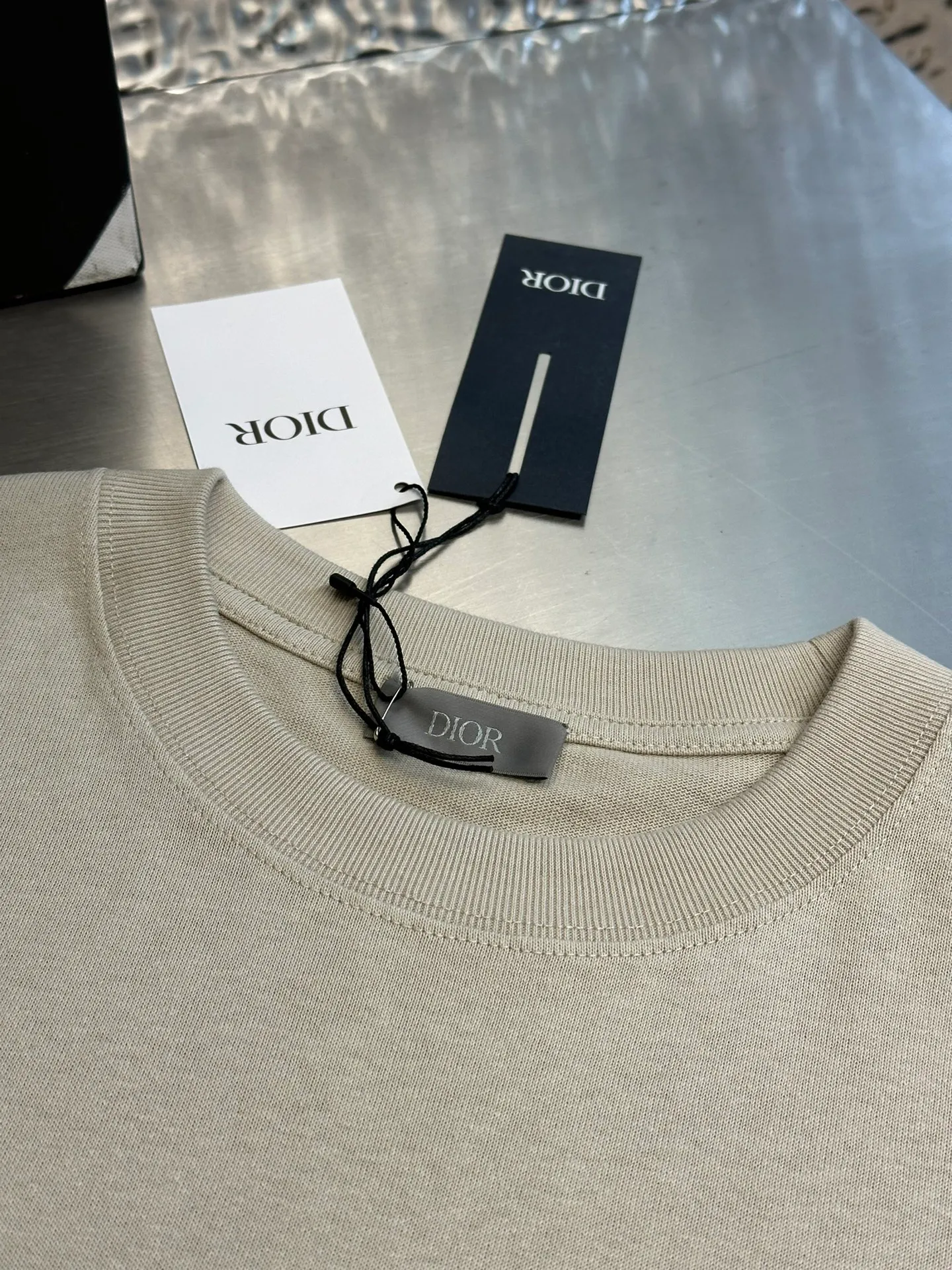 🅿️260 Dior patch letter short sleeves are made of pure cotton 12S fine cotton plain weave, weight 230g. The front is decorated with contrasting logo patches and small embroidered stamps, forming a decorative and iconic embroidery product. The logo is made of imported custom-made embroidery thread, which is dyed with lustrous mercerized embroidery thread, giving it a uniform and glossy finish. The exquisite embroidery machine combines complex embroidery needlework and fine detail processing to create a three-dimensional micro-relief embroidery effect; it is also highly durable and wear-resistant.  The standard round neck and short-sleeved version has a rounded arc neckline, which is suitable for various face shapes and body shapes; the sleeve length is moderate and ends just above the elbow, showing a smart and neat image. The slim fit can show off the wearer's body curves without sacrificing comfort. The collar, cuffs, hem and other parts are all sewn with fine double-needle stitching.  size：xs s m l
