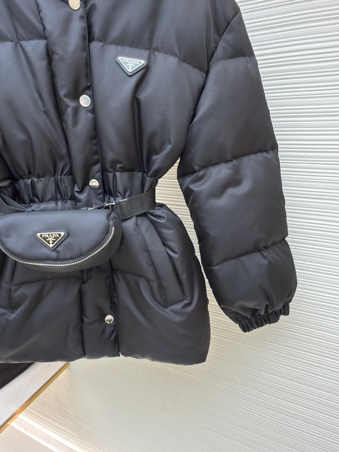 Prada Ant Waist Down Jacket [Women's Clothing] ●Original version: Purchased and developed by 18589 ●Item number: 1680810-E65 ●Fabric: nylon fabric ●Technology: Made on positioning cutting machine ●Version: Fitted version ●Weight: about 1105 grams ●Size: S-M-L ●Description: [Reshape winter style | High-end regenerated nylon long down jacket | Unlock multi-scenario wear] Made of regenerated nylon material, it not only implements the concept of sustainable fashion, but also has windproof and waterproof functions to cope with changing weather. The hooded collar and side buckle nylon webbing details enhance the sense of practicality; the elastic cuffs and drawstring hem lock in temperature and prevent wind flow, improving the overall fit. Filled with selected high-quality duck down, it is light and fluffy and has strong thermal insulation properties, so it is not afraid of severe cold challenges. The three-dimensional ant waist design, paired with a detachable belt and a functional bag of the same color, easily outlines elegant curves and can be freely switched between casual and sophisticated modes. Filled with selected high-quality duck down, it is light and fluffy and has strong thermal insulation properties, so it is not afraid of severe cold challenges. The three-dimensional ant waist design, paired with a detachable belt and a functional bag of the same color, easily outlines elegant curves and can be freely switched between casual and sophisticated modes. The overall wiring is straight and delicate, the fabric is comfortable and soft, and the color is consistent without color difference. It can be matched with the same style to create a fashionable look and control various occasions. Customized accessories, complete with three standards, same style for men and women!
