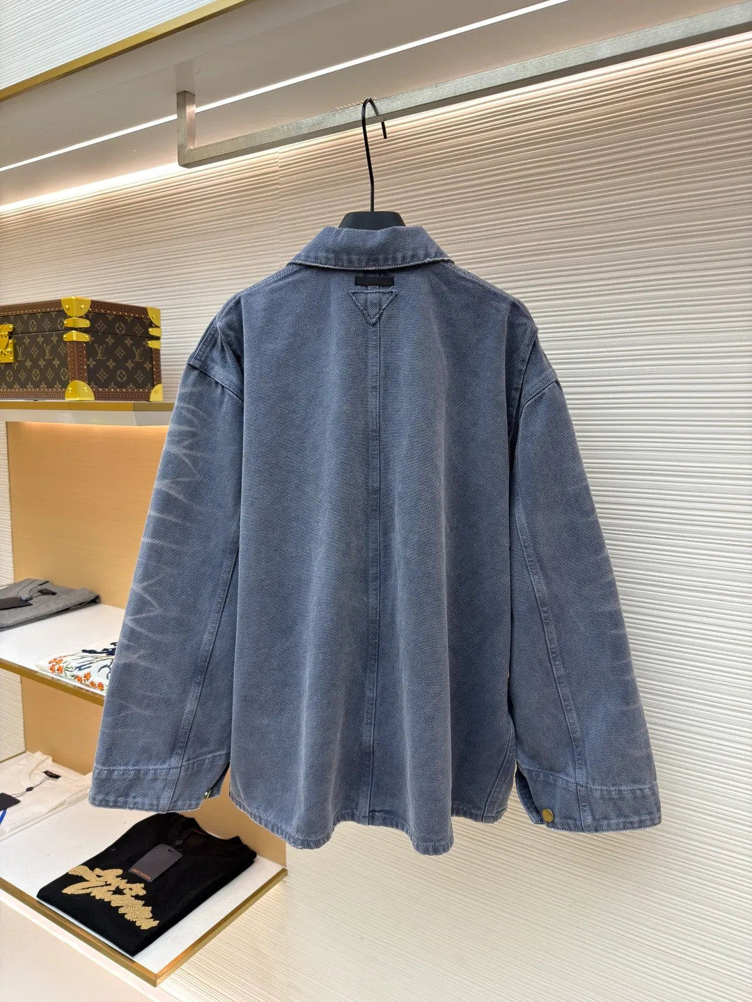 Prada distressed ice blue four-pocket work jacket ●Original version: purchased and developed by 15761 ●Item number: 1681562-B20 ●Fabric: cotton canvas fabric ●Technology: made with distressed wash ●Color: ice blue ●Version: fitted version ●Weight: about 1185 grams ●Size: S-M-L ●Description: Made of high-weight cotton canvas, specially tanned and pre-shrunk to ensure a stiff silhouette while improving durability. It adopts multi-stage artificial wear technology, including sandpaper polishing, enzyme washing and fading, and edge tearing treatment to form a natural fading gradient in stress areas such as collars, cuffs, and hems, simulating the retro traces of long-term wear.  A matte resin coating is applied to the surface, which not only retains the rough texture of the canvas, but also enhances windproof and anti-fouling properties, embodying Prada's "functional luxury" concept. The main stitching uses luxury-grade 20/3-strand high-twist thread, while the decorative topstitching is replaced with 0.1mm ultra-fine polyester thread, creating a visual contrast between fragility and solidity.  Customized distressed matte hardware accessories, with the PRADA dark pattern logo engraved on the bottom, implementing the "unfinished" design philosophy. This jacket is essentially a sophisticated game of materials - deconstructing workwear prototypes with the precision engineering of high fashion, and reconstructing the value narrative with anti-luxury old-fashioned techniques, fully presenting the concept of "Imperfect Sublime" proposed by Miuccia Prada. The overall wiring is straight and delicate, the fabric is comfortable and soft, and the color is consistent without color difference. It can be matched with the same style to create a fashionable look and control various occasions. Customized accessories, complete with three standards, same style for men and women!