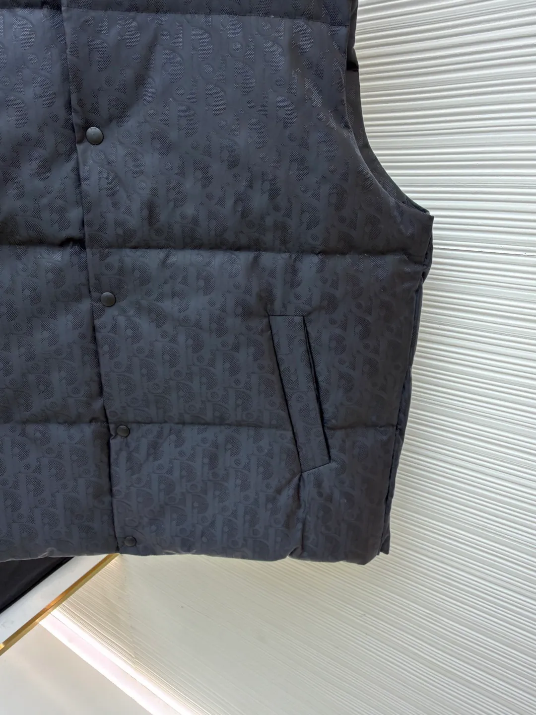 Dior dark pattern jacquard all-over print vest ●Original version: Purchased and developed for 17999 ●Item number: 1681378-C85 ●Fabric: white duck down fabric ●Technology: jacquard production ●Color: black ●Version: fitted version ●Weight: about 600 grams ●Size: S-M-L ●Description: This vest is made of full-width brand iconic jacquard fabric, with dark gray shading to present a low-key luxury texture. Using three-dimensional quilting technology, down is evenly filled into the grid-like partitions to ensure warmth while creating a full and crisp silhouette. The stand-up collar design and metal button placket make it easy to put on and take off and enhance the layering of the look. Hidden diagonal pockets are used on both sides, taking into account practicality and overall aesthetics. From fabric weaving to down filling, every process is strictly controlled: the jacquard process ensures clear and three-dimensional pattern texture, the quilting lines are neat and even, and the buttons are made of high-quality metal material, which is durable. The overall craftsmanship exquisitely integrates brand recognition, thermal function and fashionable design, showing superb clothing making standards and high-end taste. Purchase the original version for development, order the color and dye it, and feel free to compare it with any version on the market!