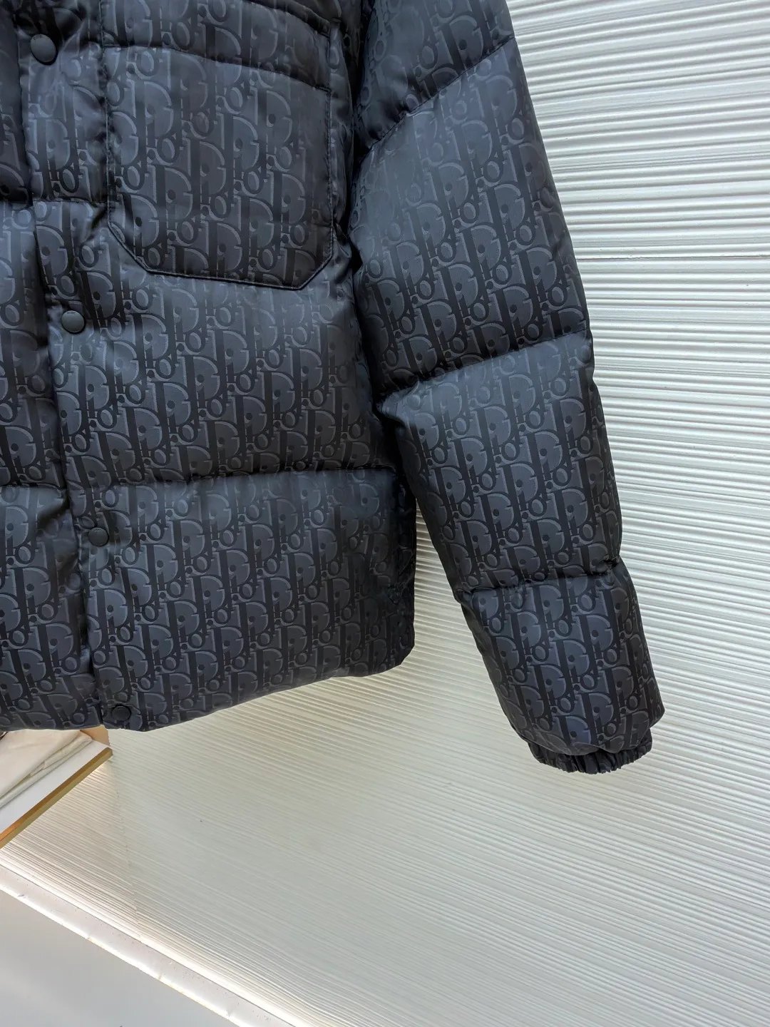 Dior 25ss jacquard all-over printed down jacket ●Original version: purchased and developed by 21894 ●Item number: 1682014-D35 ●Fabric: white duck down fabric ●Technology: jacquard production ●Color: black ●Version: fitted version ●Weight: about 800 grams ●Size: 46-48-50-52 ●Description: The fabric adopts scientific jacquard technology: laser jacquard technology is applied to the fabric to make the whole piece of clothing uneven and more three-dimensional. This technology not only improves the visual effect of the fabric, but also enhances its durability and comfort. Custom-woven high-density satin nylon material, combined with dark jacquard weaving, makes the down vest extremely waterproof, anti-fouling, and dust-proof. This ensures that the vest will look and perform well in inclement weather. Oblique printing is applied to fabrics through precise printing technology and blends perfectly with the fabrics, presenting a low-key and luxurious visual effect. High-quality 90% white duck down is used as the filling, and it has been strictly processed and screened to ensure the fluffiness and warmth of the down. Evenly fill the down into the inner bladder of the vest and fix it by sewing and taping. Detailed processing is done on the collar, cuffs, hem and other parts of the vest to improve the practicality and beauty of the vest. At the same time, the vests are ironed and inspected to ensure that the product quality meets the standards. The overall wiring is straight and delicate, the fabric is comfortable and soft, and the color is consistent without color difference. It can be matched with the same style to create a fashionable look and control various occasions. Customized accessories, complete with three standards, same style for men and women!