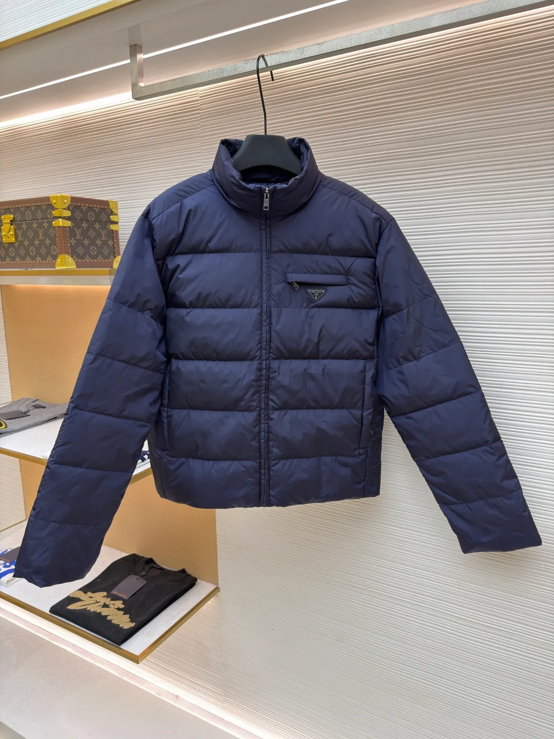 Prada triangle pocket down jacket ●Original version: Purchased and developed in 19800 ●Item number: 1681903-D20 ●Fabric: white duck down fabric ●Technology: mechanical down filling ●Color: navy blue ●Version: fitted version ●Weight: about 675 grams ●Size: 46-48-50-52 ●Description: Customized ultra-dense round hole woven fabric (with anti-repellent treatment) showing a matte micro-texture Use the new national standard 90 white duck down (welcome to test), full of down, full of warmth, you are in a warm cloud, surrounded by soft warmth, the classic black tone exudes an innate sense of luxury, the iconic enameled metal triangle logo is embellished on the chest, low-key and powerful, the stand-up collar is crisp and stylish, accurately fits the neck curve, and uses architectural lines to reconstruct the warmth and neatness of the bloated down jacket. Enjoy warmth and comfort. Become the most considerate companion for mechanical down filling in winter. Prioritize the filling area by making the liner pattern to determine the gram weight of down per square meter according to the original three-dimensional effect, thereby calculating the filling amount of each piece. The computer down filling machine uses a digital weighing unit to achieve stable measurement, and uses imported special machine infrared to locate the "Prada triangle mark" for more accurate positioning. The firm and strong template machine opens the zipper bag. The lines are smooth and tidy. The wiring is even and the template machine lines the lines. The line process of the computer template machine shows extremely high neatness and smoothness. The craftsman accurately controls the size during the operation to ensure that each line meets the design requirements. The lines of the entire template are smooth and uniform, clean and beautiful. The overall wiring is straight and delicate, the fabric is comfortable and soft, and the color is consistent without color difference. It can be matched with the same style to create a fashionable look and control various occasions. Customized accessories, complete with three standards, same style for men and women!