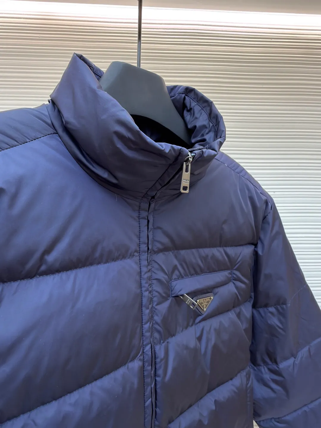 Prada triangle pocket down jacket ●Original version: Purchased and developed in 19800 ●Item number: 1681903-D20 ●Fabric: white duck down fabric ●Technology: mechanical down filling ●Color: navy blue ●Version: fitted version ●Weight: about 675 grams ●Size: 46-48-50-52 ●Description: Customized ultra-dense round hole woven fabric (with anti-repellent treatment) showing a matte micro-texture Use the new national standard 90 white duck down (welcome to test), full of down, full of warmth, you are in a warm cloud, surrounded by soft warmth, the classic black tone exudes an innate sense of luxury, the iconic enameled metal triangle logo is embellished on the chest, low-key and powerful, the stand-up collar is crisp and stylish, accurately fits the neck curve, and uses architectural lines to reconstruct the warmth and neatness of the bloated down jacket. Enjoy warmth and comfort. Become the most considerate companion for mechanical down filling in winter. Prioritize the filling area by making the liner pattern to determine the gram weight of down per square meter according to the original three-dimensional effect, thereby calculating the filling amount of each piece. The computer down filling machine uses a digital weighing unit to achieve stable measurement, and uses imported special machine infrared to locate the "Prada triangle mark" for more accurate positioning. The firm and strong template machine opens the zipper bag. The lines are smooth and tidy. The wiring is even and the template machine lines the lines. The line process of the computer template machine shows extremely high neatness and smoothness. The craftsman accurately controls the size during the operation to ensure that each line meets the design requirements. The lines of the entire template are smooth and uniform, clean and beautiful. The overall wiring is straight and delicate, the fabric is comfortable and soft, and the color is consistent without color difference. It can be matched with the same style to create a fashionable look and control various occasions. Customized accessories, complete with three standards, same style for men and women!